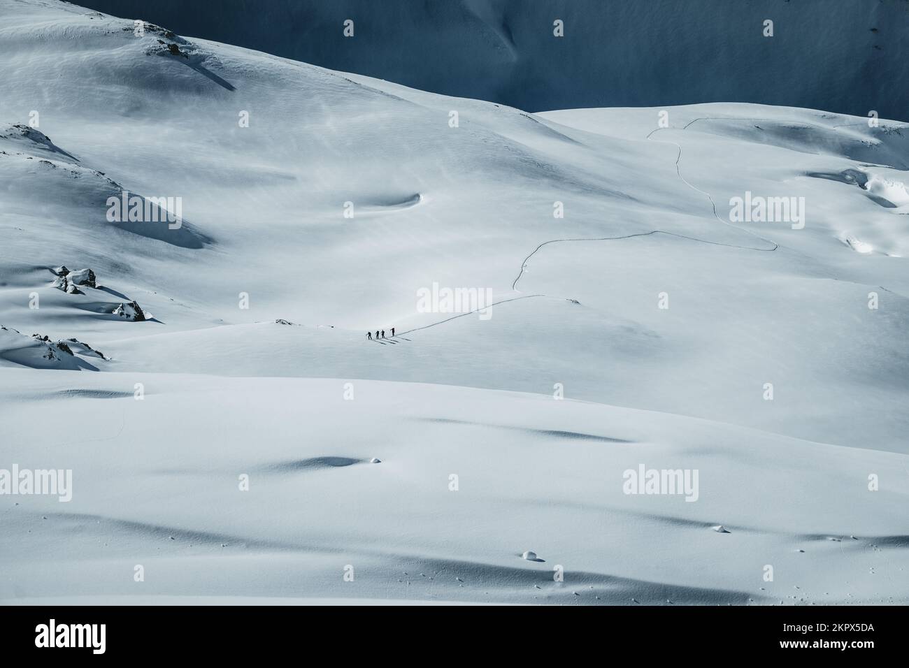 Vista in lontananza di quattro persone scialpinismo nelle Alpi austriache, Gastein, Salisburgo, Austria Foto Stock