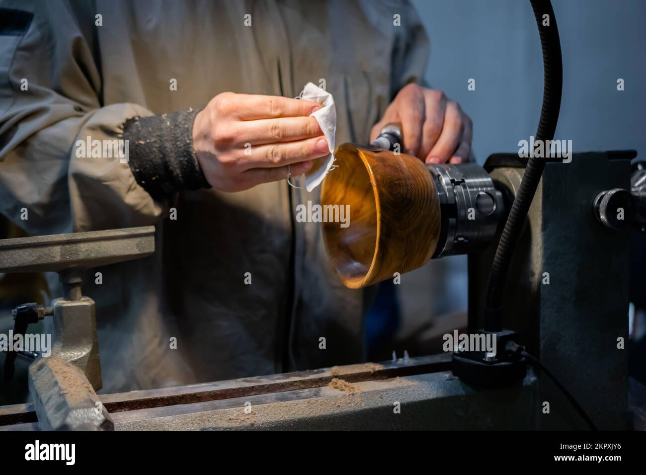 Carpentiere professionale oliatura vaso in legno finito su tornio in legno Foto Stock