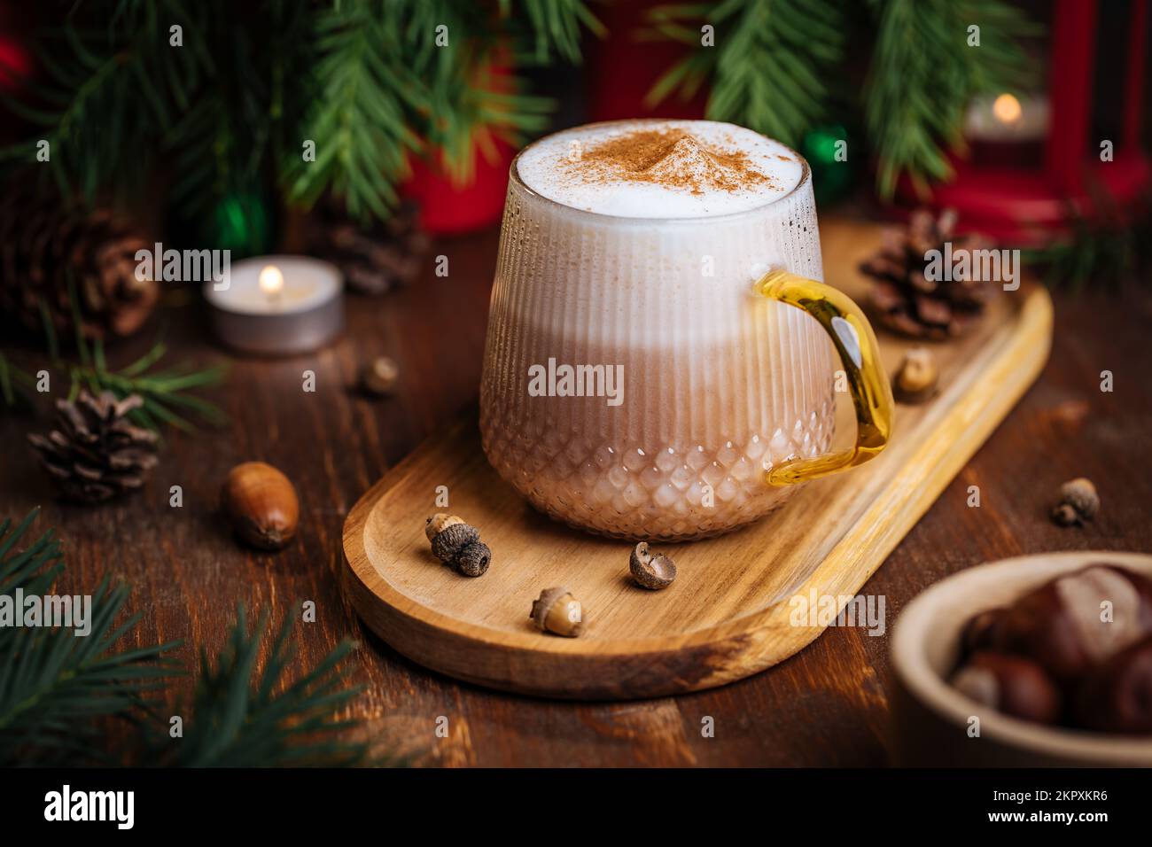 Tazza di vetro di zucca speziata tardi o di melone in un'atmosfera festosa, accogliente e di Natale inverno. Sensazione di umore a casa. Foto Stock