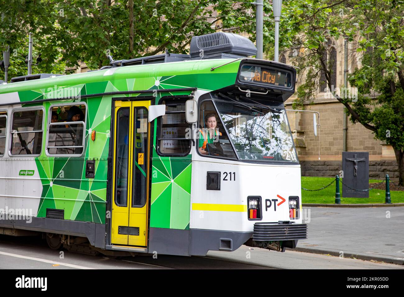 Donna australiana che guida con un tram di Melbourne nel centro della città, Victoria, Australia Foto Stock