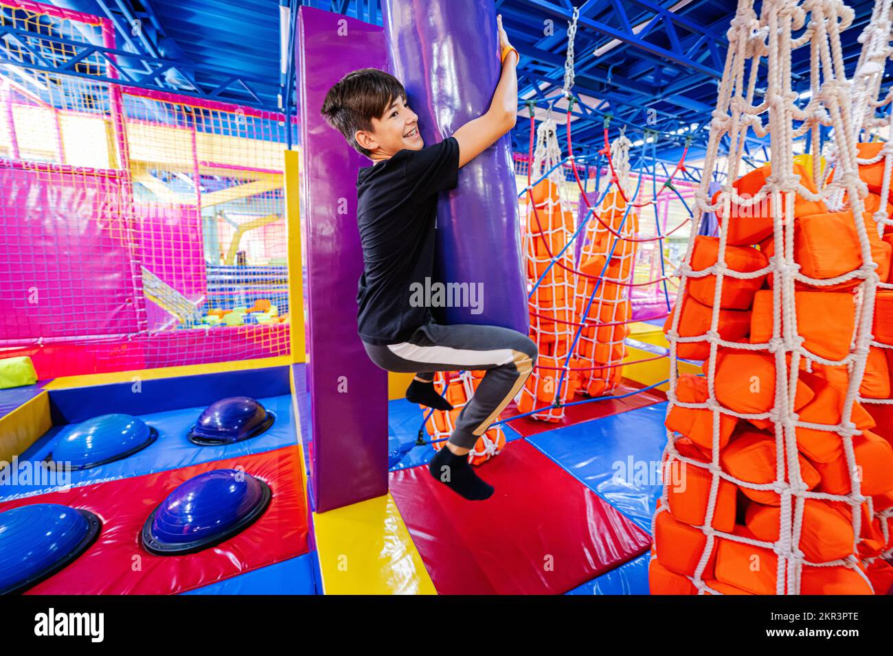 Ragazzo che gioca nel parco giochi al coperto. Foto Stock