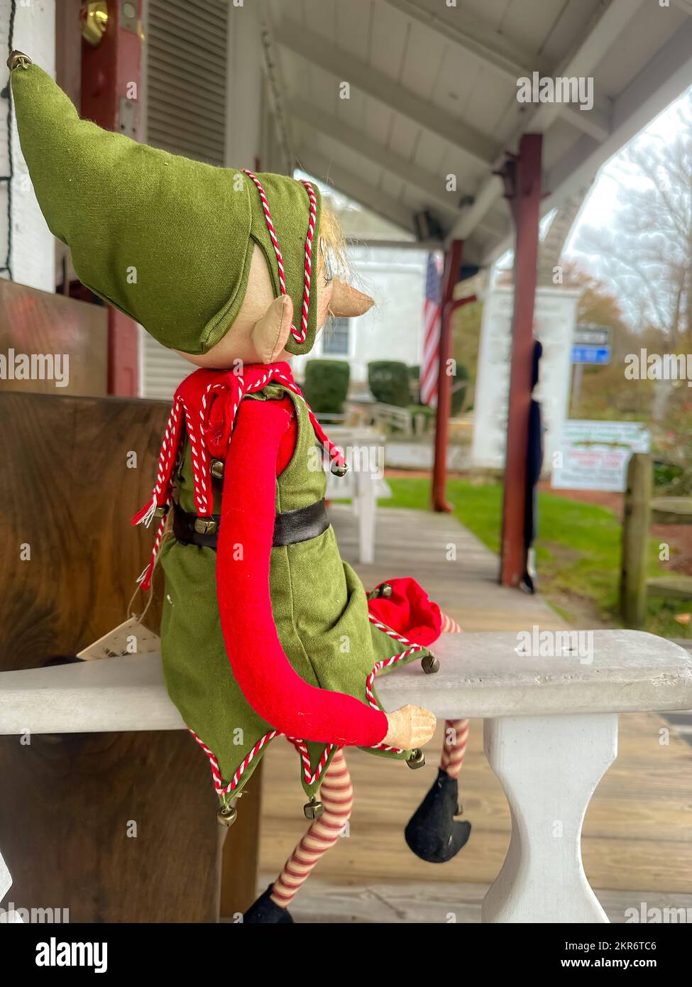 Foto di un Elf di vacanza seduto sul braccio di una panca esterna. Foto Stock