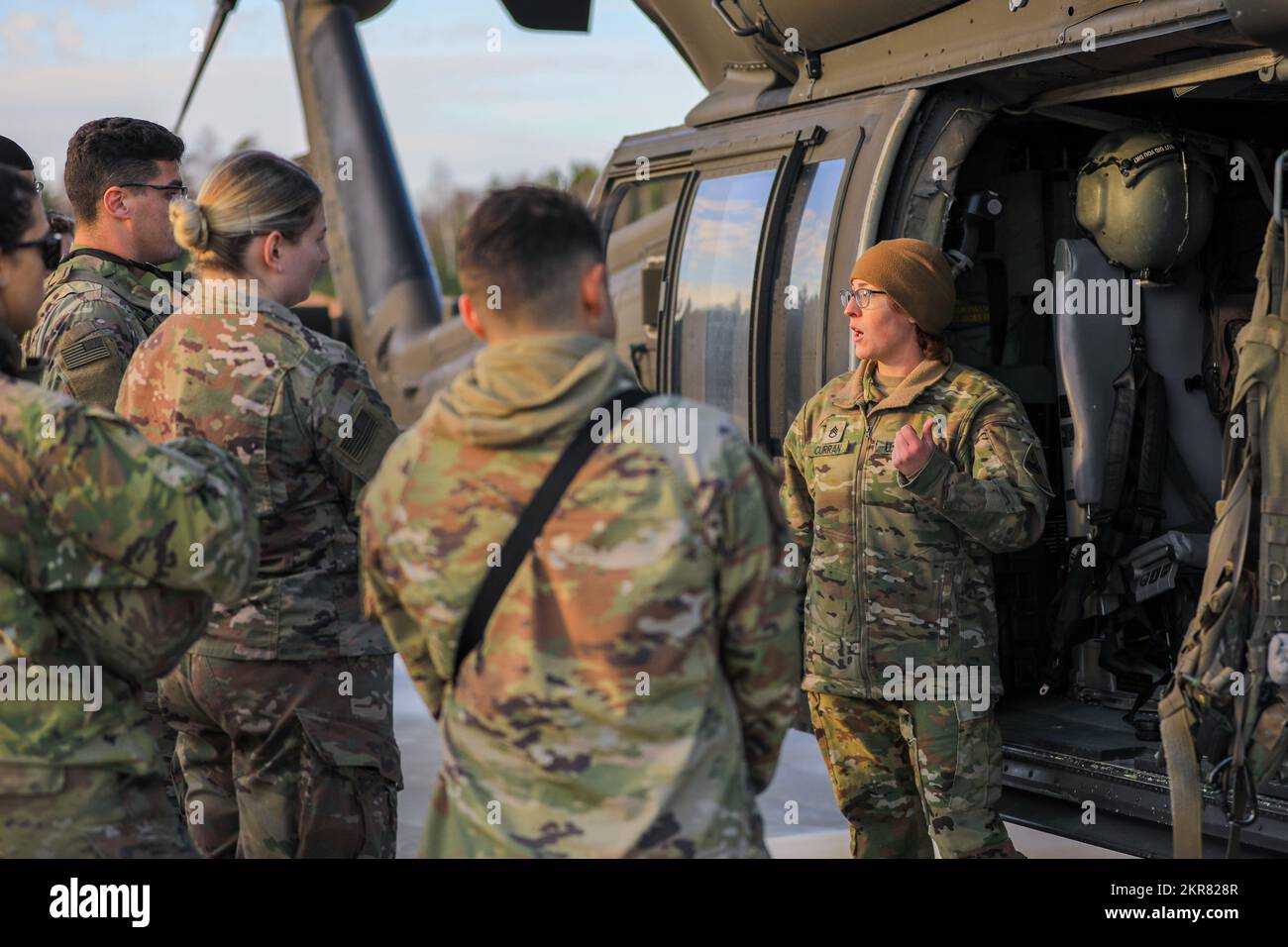 STATI UNITI I soldati assegnati a Bravo Battery, Death Dealers, 2nd battaglione, 174th reggimento artiglieria di difesa aerea (2-174 ADA), ricevono una formazione di medevac e paranco dal personale Sgt. Emily K. Curran, un paramedico di volo assegnato a 1st Forward Support Medical Platoon, Charlie Company, 2nd battaglione, 501st battaglione Aviazione di supporto generale, 2nd battaglione, 501st Aviation Regiment (2-501 AR), entrambi controllati operativamente da 1st divisione fanteria (1 ID) durante l'esercizio di addestramento sul campo incontro ravvicinato a Camp Ādaži, Lettonia, 9 novembre 2022. I modelli 2-174 ADA e 2-501 AR sono tra le altre unità assegnate a. Foto Stock