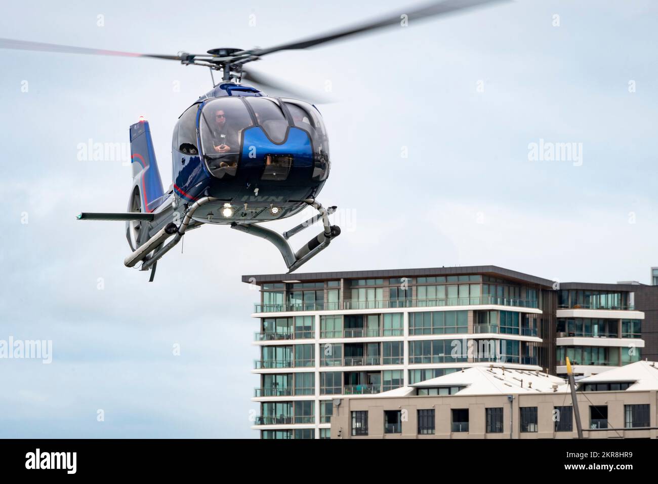 Elicottero che vola in basso vicino agli edifici della città, Wellington, North Island, Nuova Zelanda Foto Stock