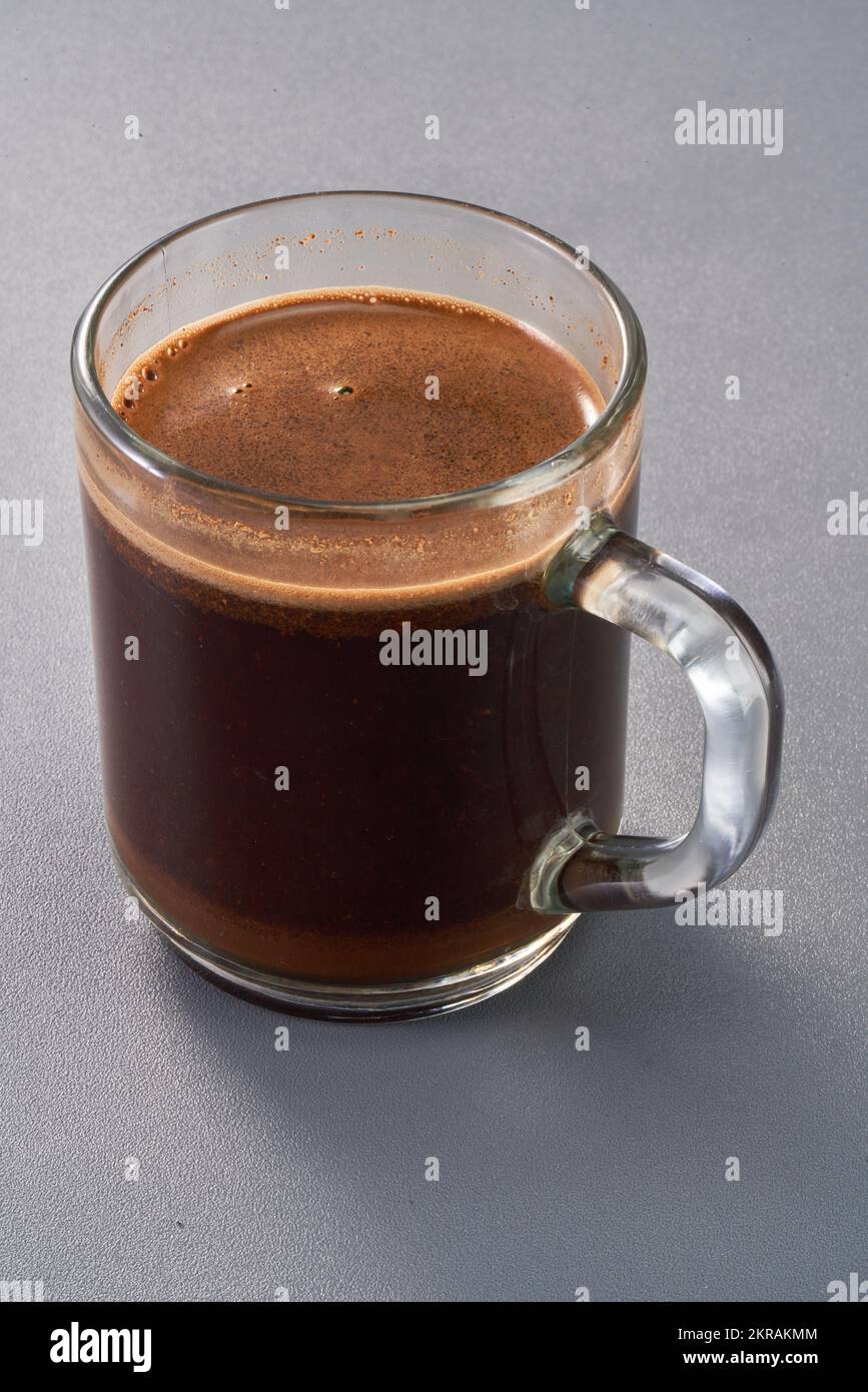 un bicchiere di caffè estratto in una tazza trasparente con crema sulla parte superiore Foto Stock