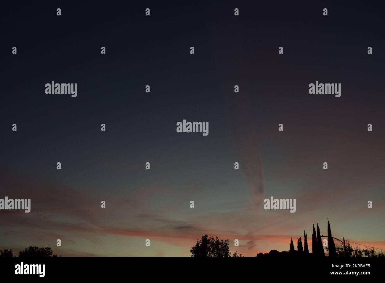 Sfuma il tramonto con gli alberi sullo sfondo Foto Stock