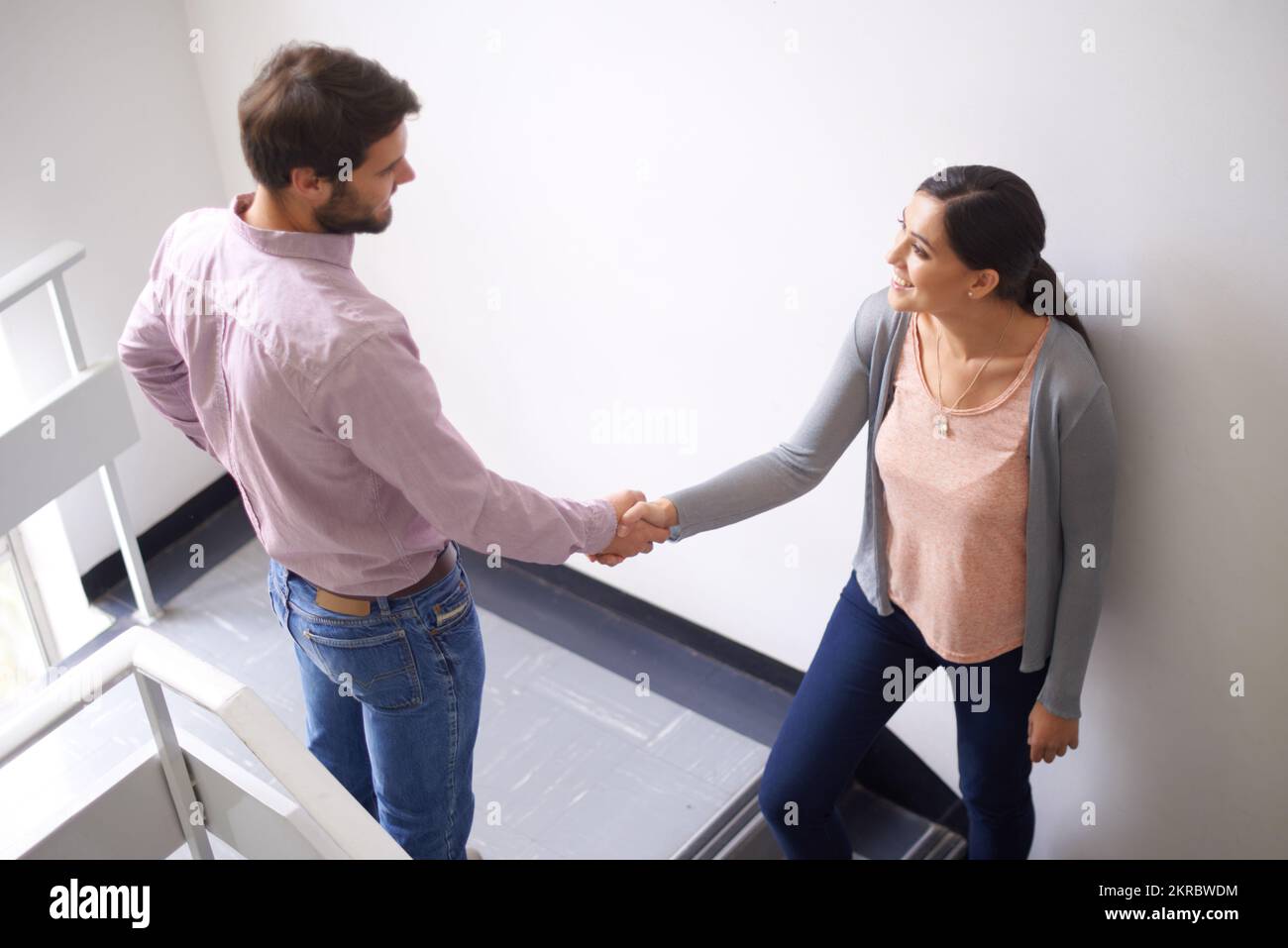 Youll andare lontano. due giovani che scuotono le mani in una scala. Foto Stock