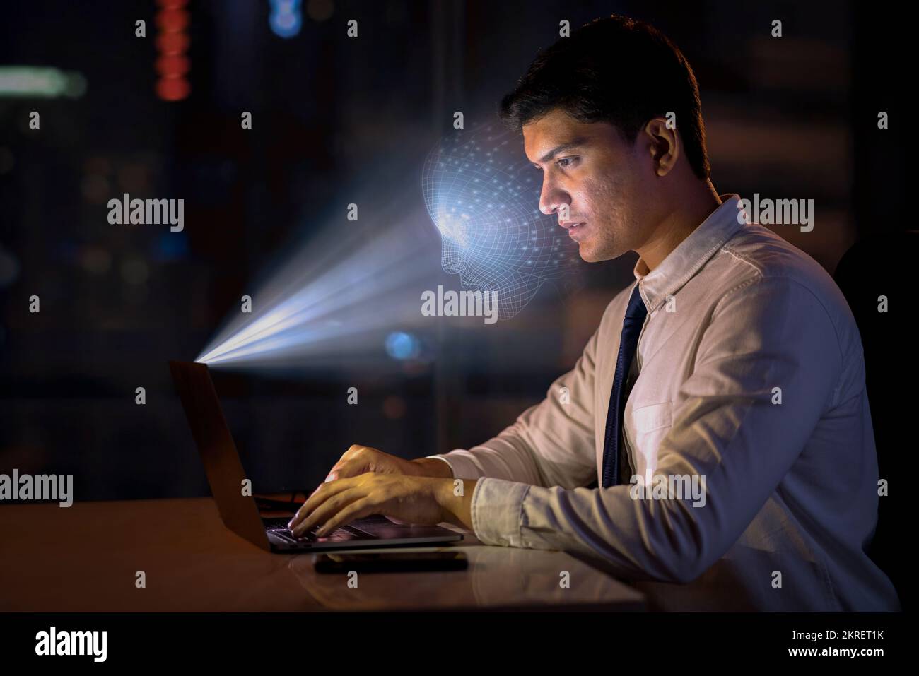 Giovane uomo che utilizza la tecnologia di riconoscimento facciale con il notebook Foto Stock