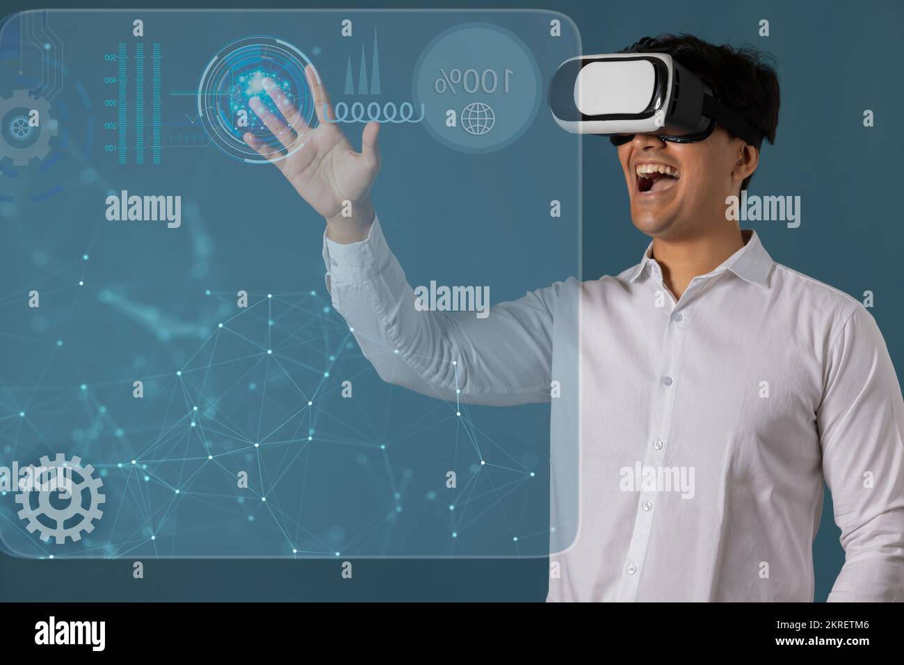 Uomo che indossa il visore VR e punta verso lo schermo digitale Foto Stock