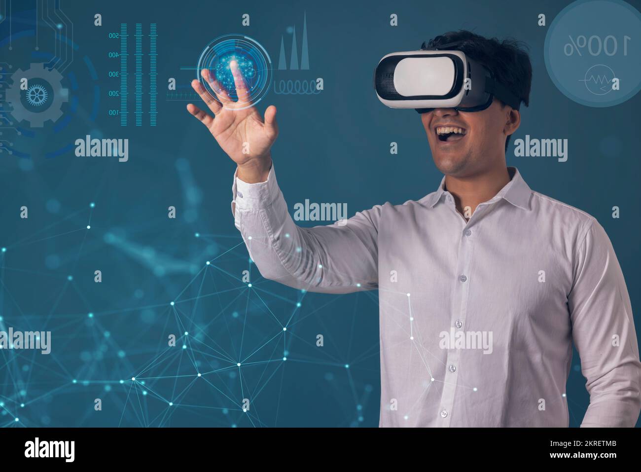 Uomo che indossa il visore VR e punta verso lo schermo digitale Foto Stock