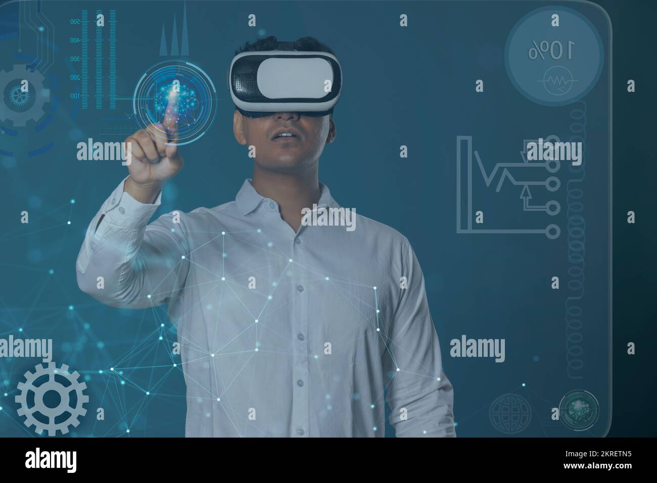 Uomo che indossa il visore VR e punta verso lo schermo digitale Foto Stock