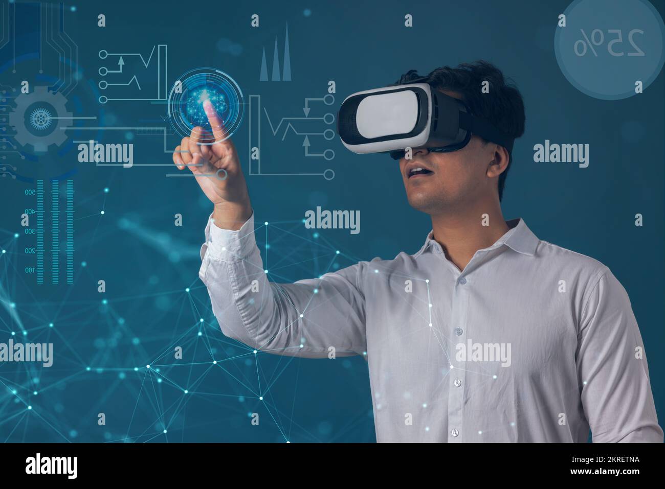 Uomo che indossa il visore VR e punta verso lo schermo digitale Foto Stock