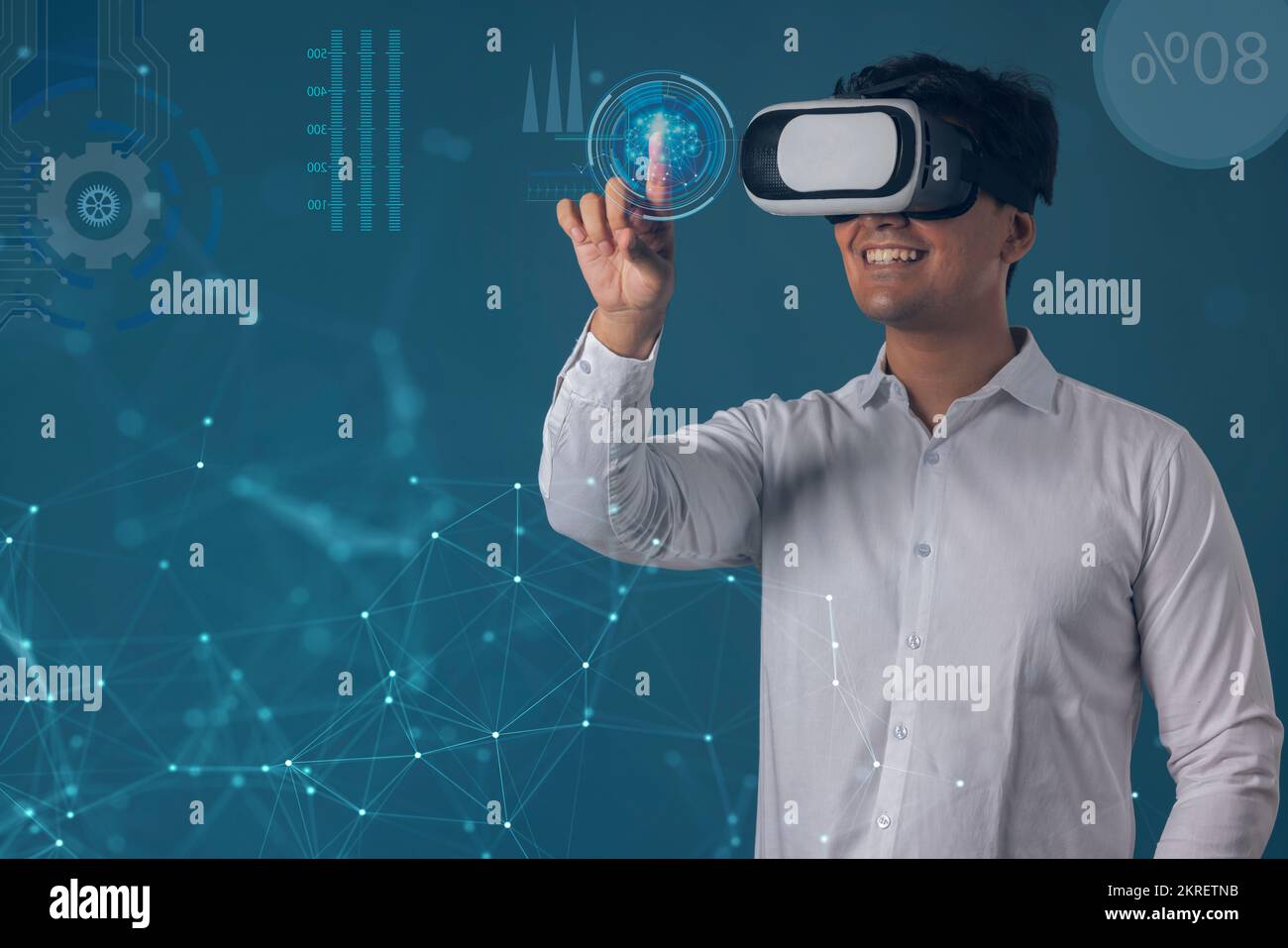 Uomo che indossa il visore VR e punta verso lo schermo digitale Foto Stock