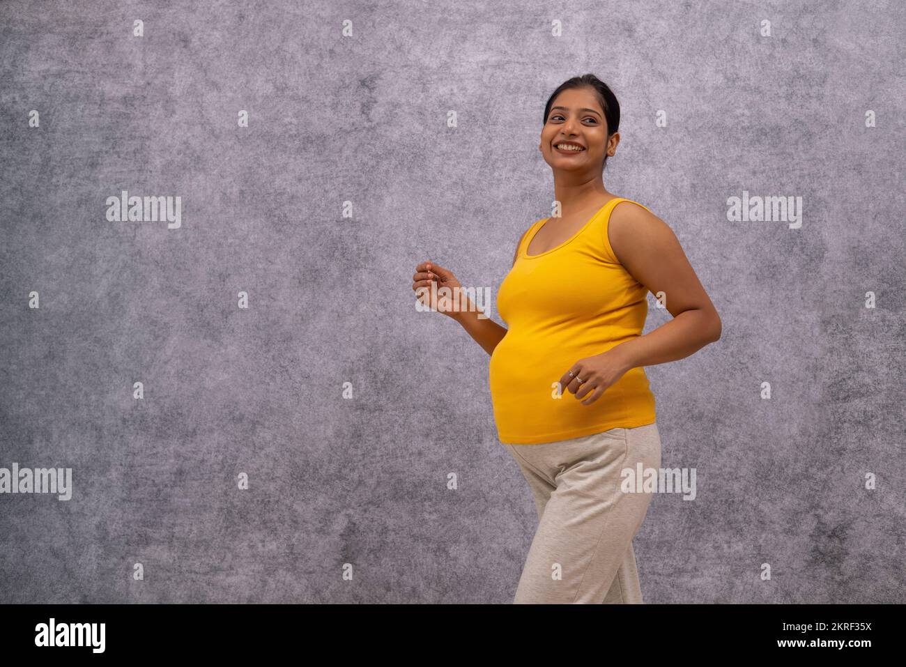 Ritratto di donna incinta sorridente che cammina Foto Stock