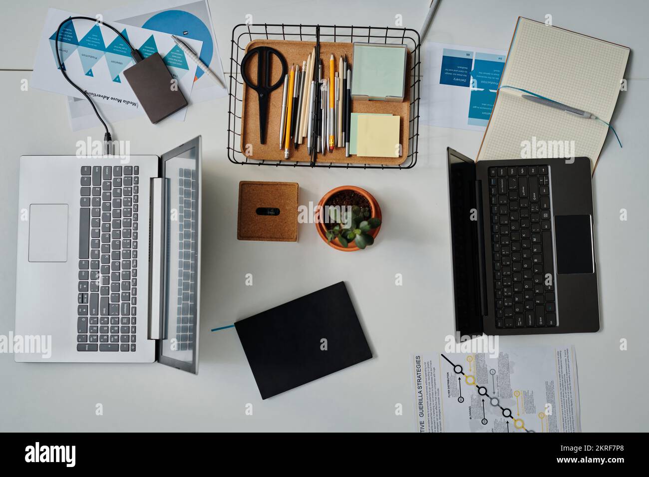 Visualizzazione ad angolo elevato del luogo di lavoro dei lavoratori in ufficio con computer per il lavoro online con documenti e forniture per ufficio Foto Stock