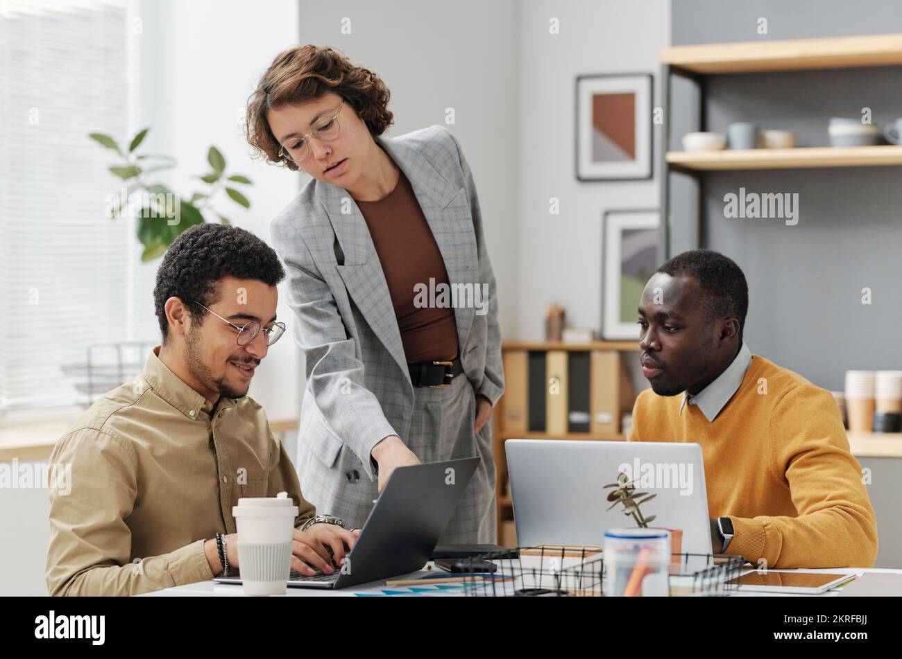 Giovani programmatori che lavorano in team durante la riunione, lavorano su computer con nuovo software Foto Stock