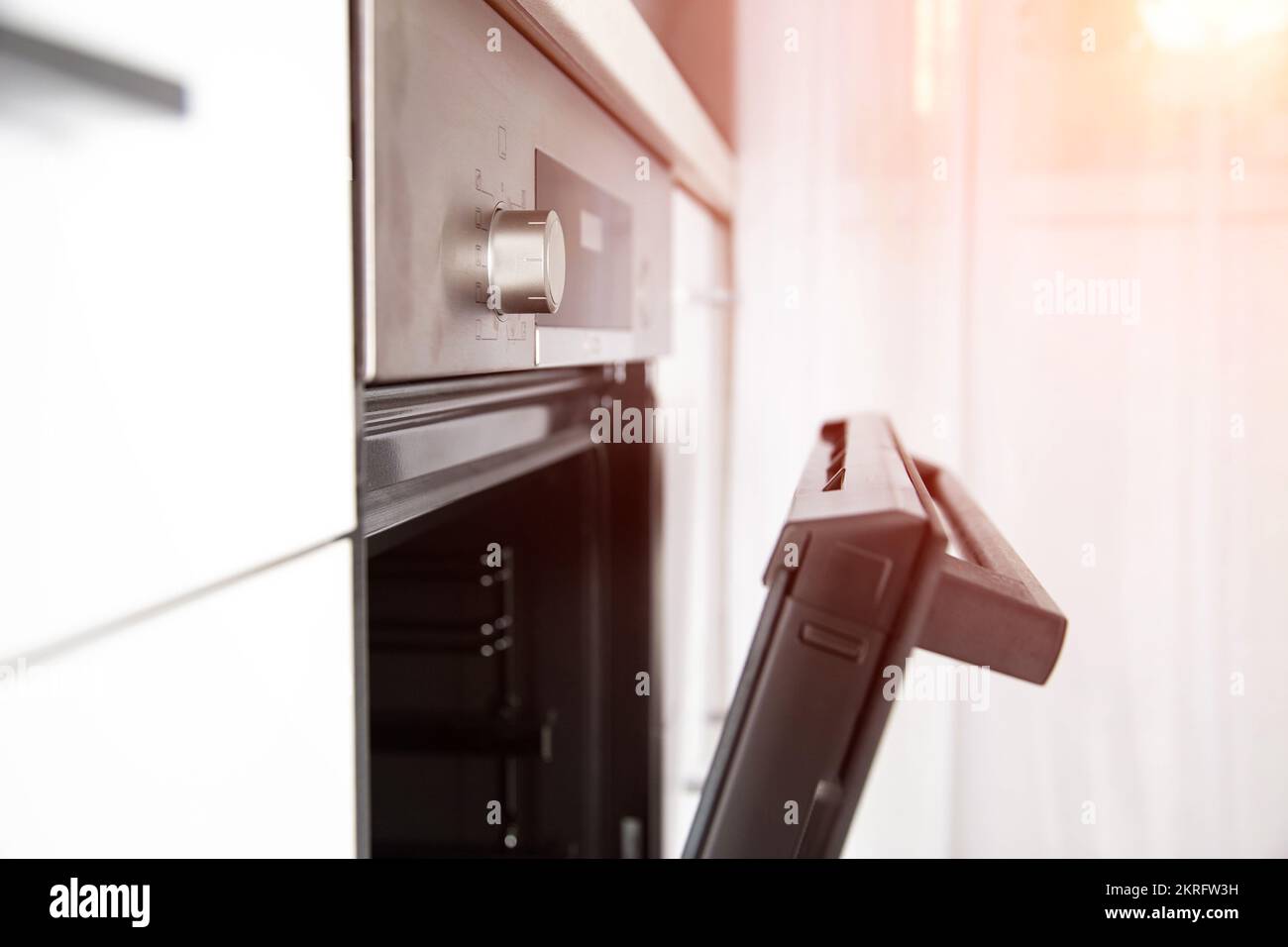 Moderno forno elettrico con porta a cerniera, orologio e funzione di cottura. Foto Stock