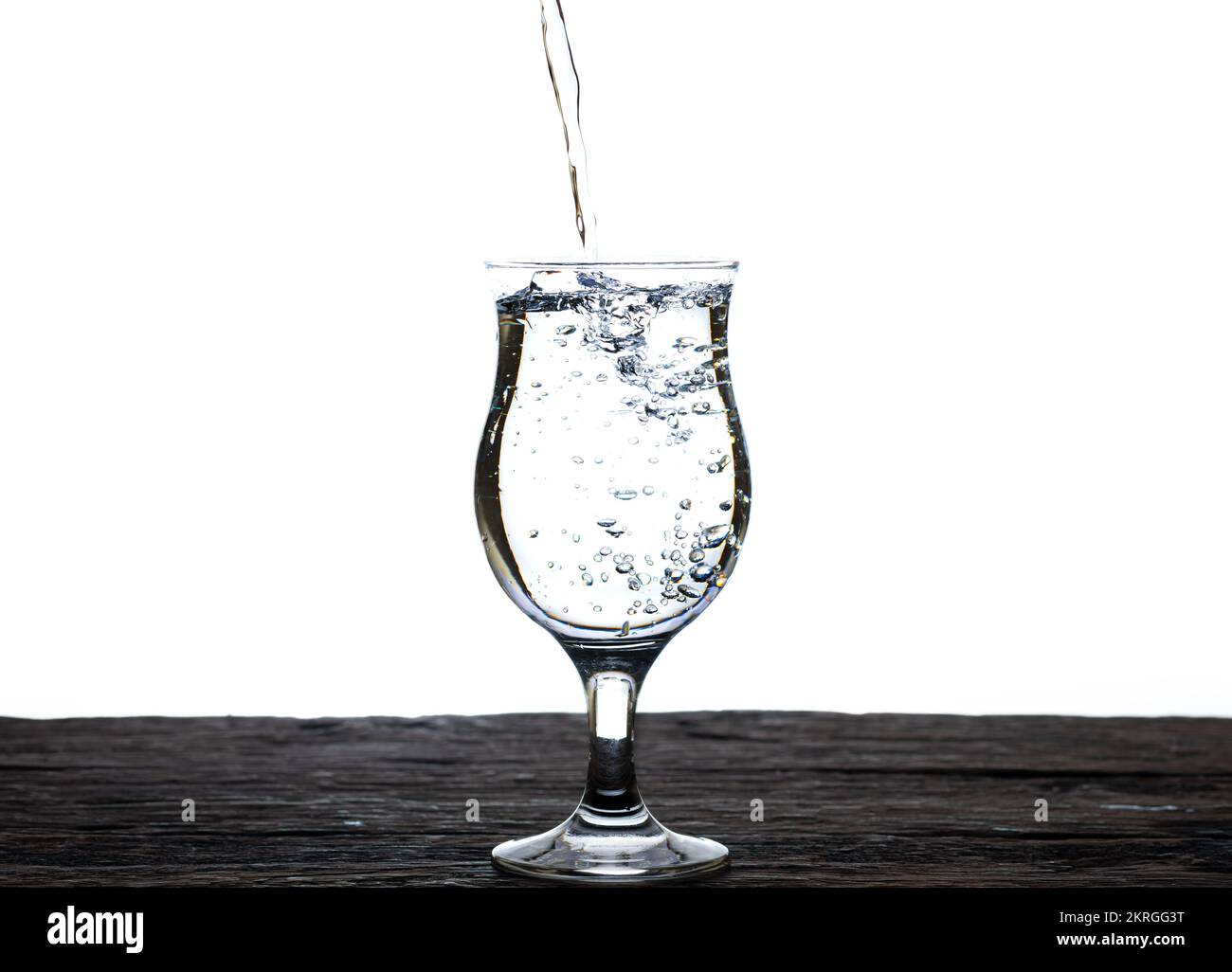 L'immagine di versare acqua potabile, in un bicchiere, che fa sentire rinfrescato isolato su sfondo bianco, spruzzi d'acqua, acqua frizzante Foto Stock