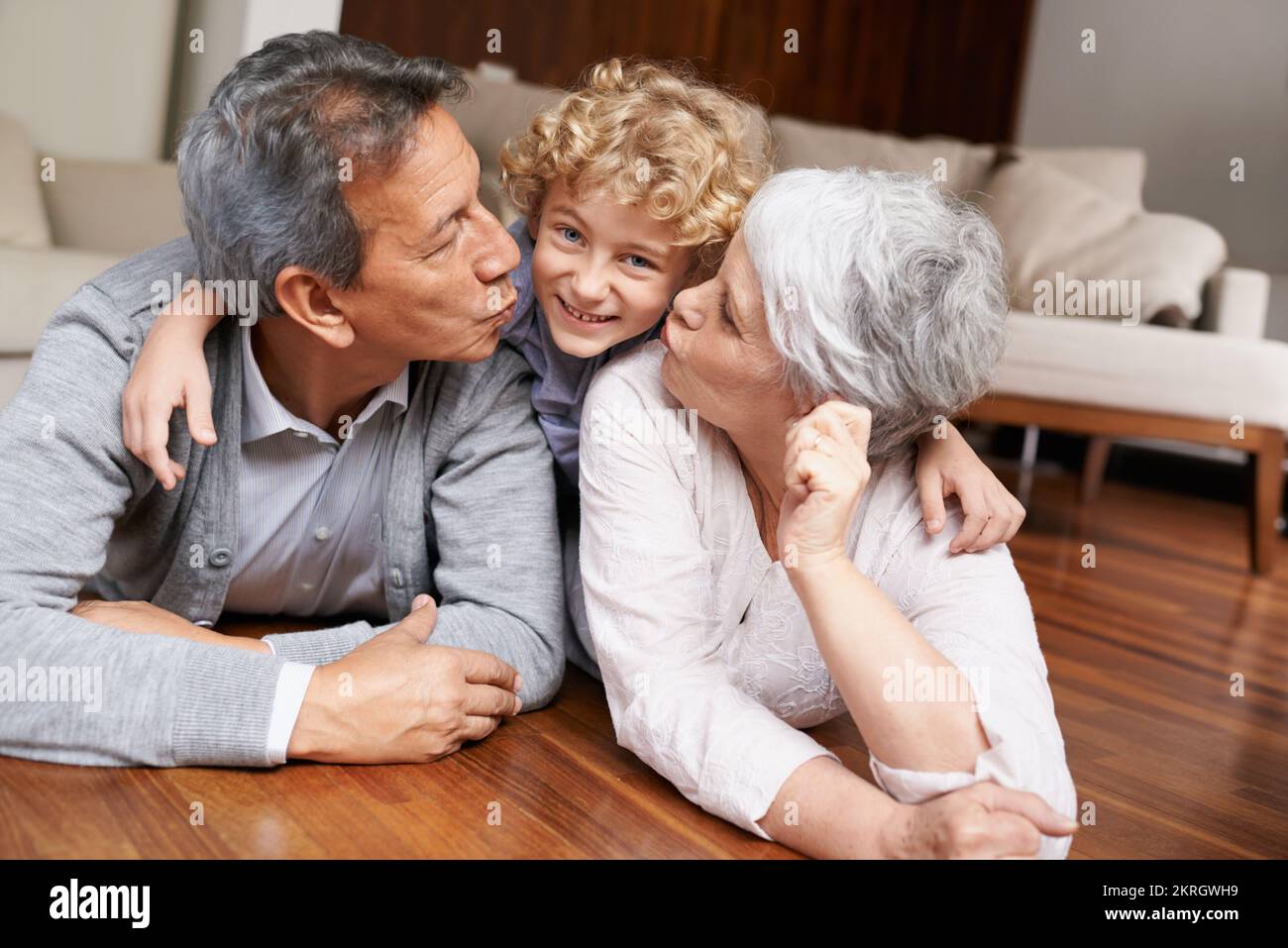 I nipoti sono una benedizione. Un ragazzino sdraiato e sorridente con i nonni. Foto Stock