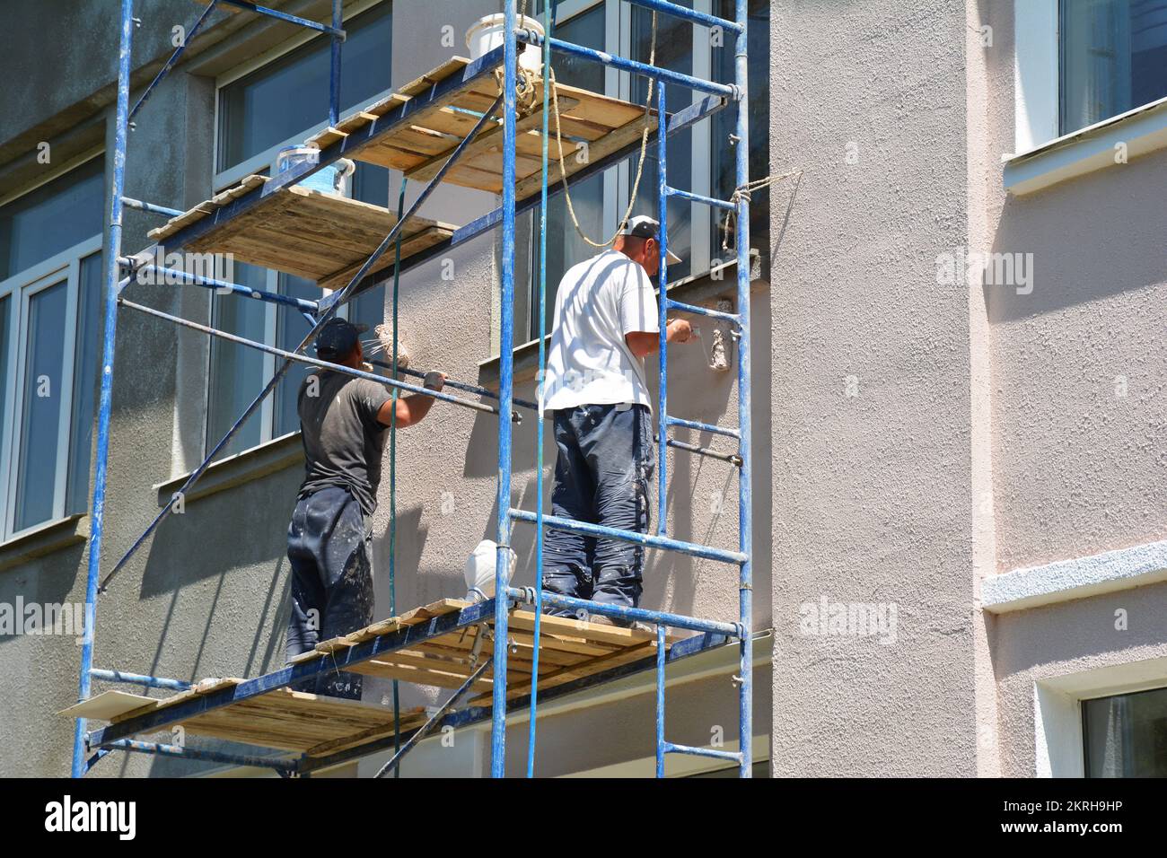 Costruttori appaltatori pittura pareti esterne facciata casa. Primo piano sulla casa di pittura al di fuori del muro. Foto Stock