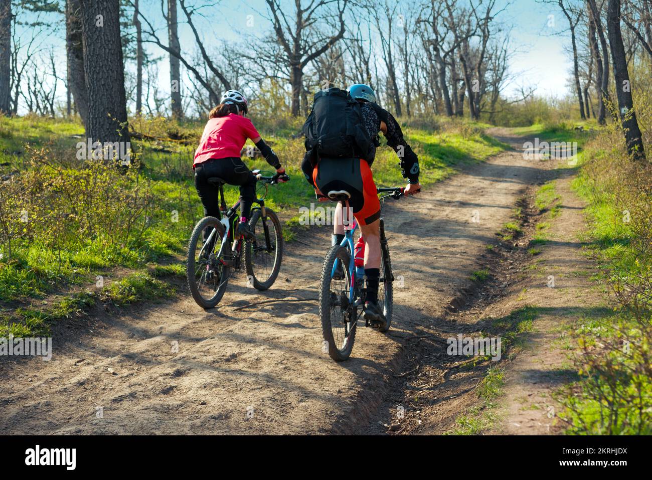 Coppia in bicicletta sulla strada sterrata nel bosco Foto Stock