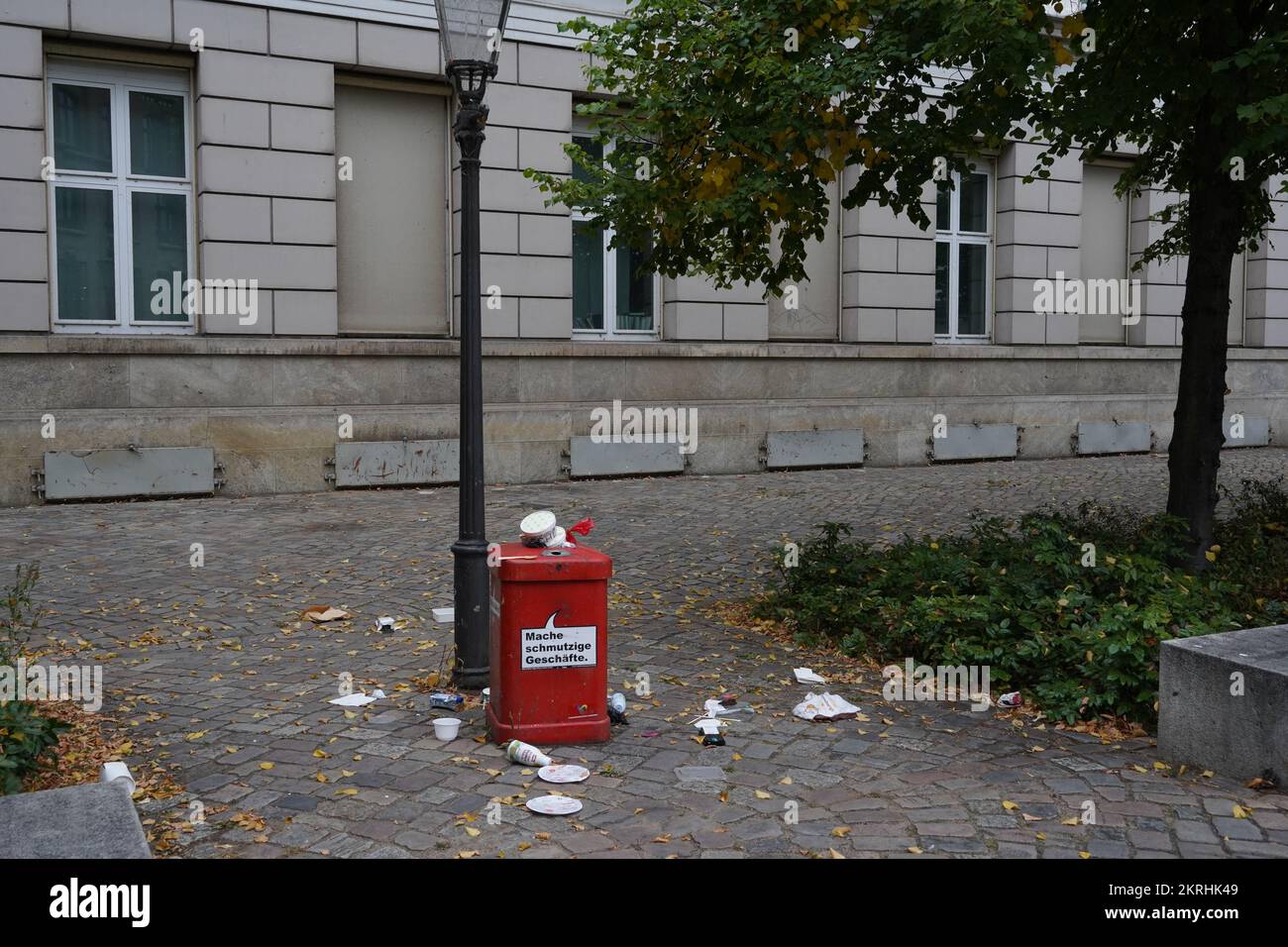 Cestino rosso sulla strada con un'iscrizione in tedesco che dice che faccio affari sporchi. Foto Stock