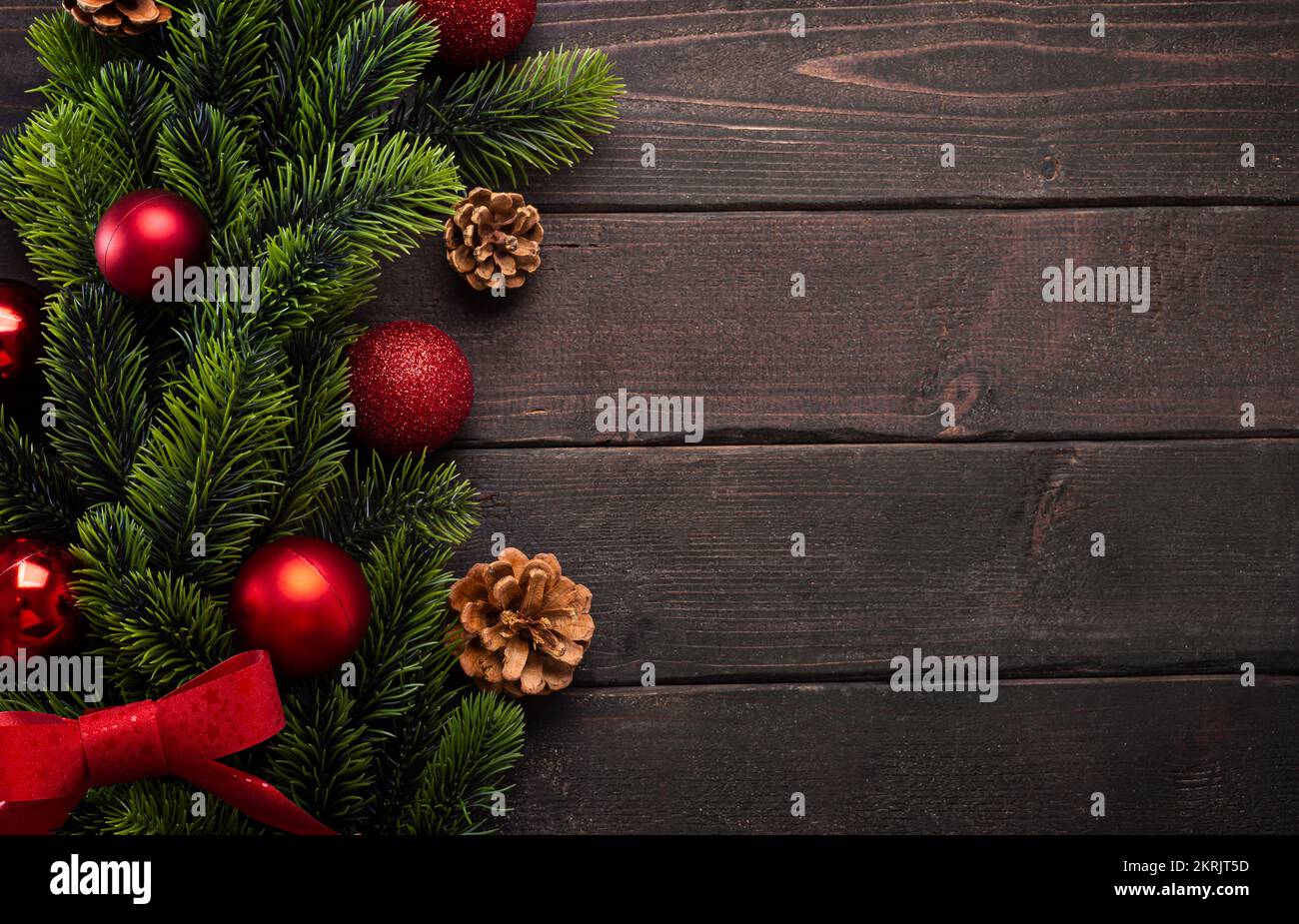 Decorazioni natalizie con rami di abete, palle di Natale e coni su tavole marroni, vista dall'alto Foto Stock