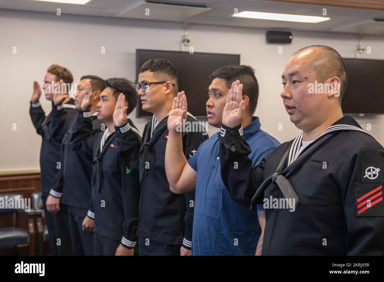 I marinai e i familiari con sede a Sasebo si impegnano a dare il giuramento di naturalizzazione di Allegiance agli Stati Uniti d'America durante una cerimonia di naturalizzazione al Comandante, Fleet Activities Sasebo 21 novembre 2022. STATI UNITI Citizenship and Immigration Services and Region Legal Service Office Western Pacific ha collaborato per condurre la cerimonia di naturalizzazione al CFAS consentendo ai marinai di diventare cittadini degli Stati Uniti. Foto Stock