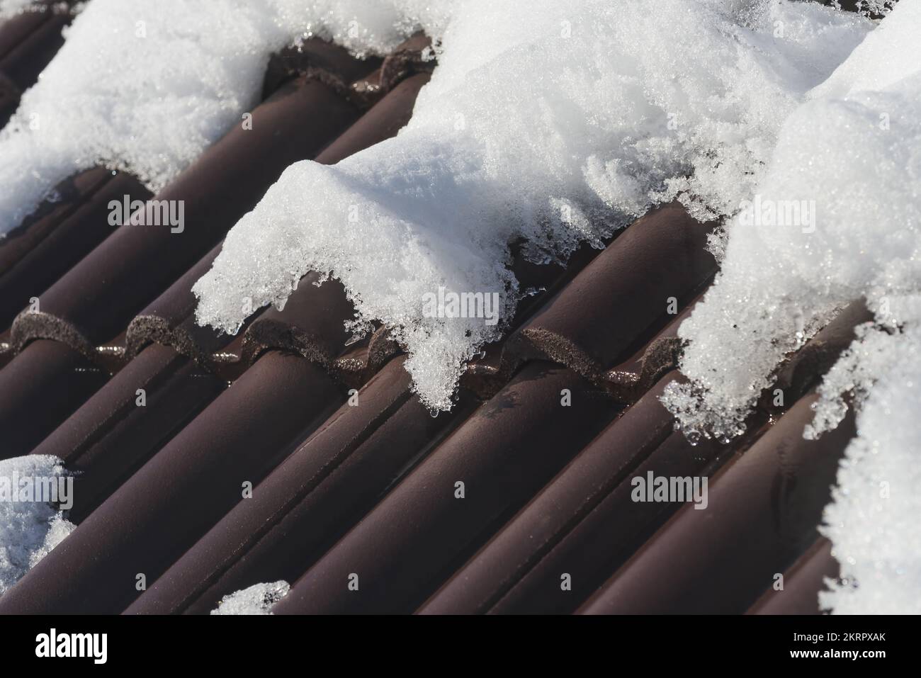 Tegole del tetto della casa sotto la neve in inverno, fuoco selettivo Foto Stock