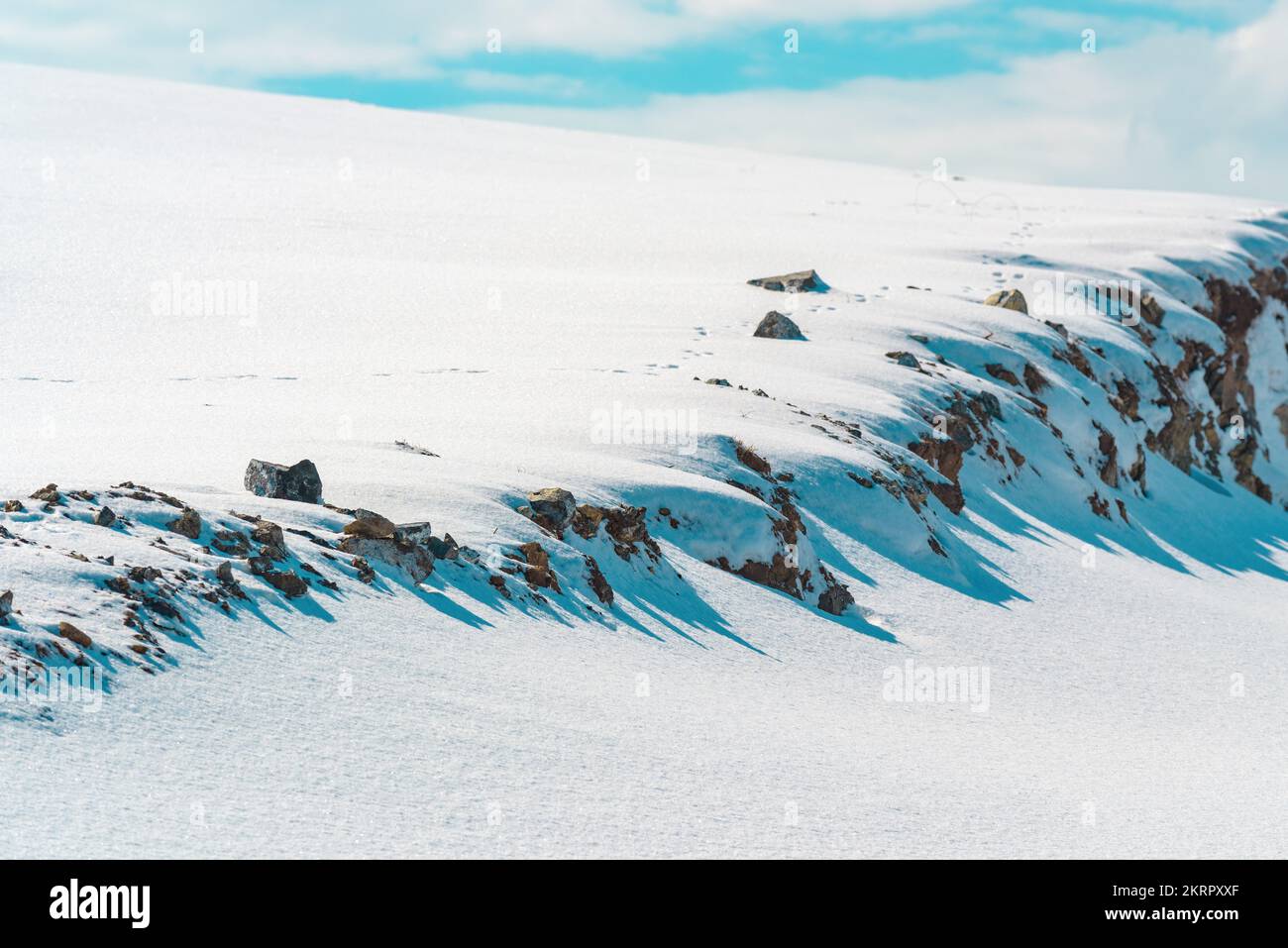 Paesaggio invernale, collina di montagna ricoperta di neve bianca pura con cielo blu sullo sfondo Foto Stock
