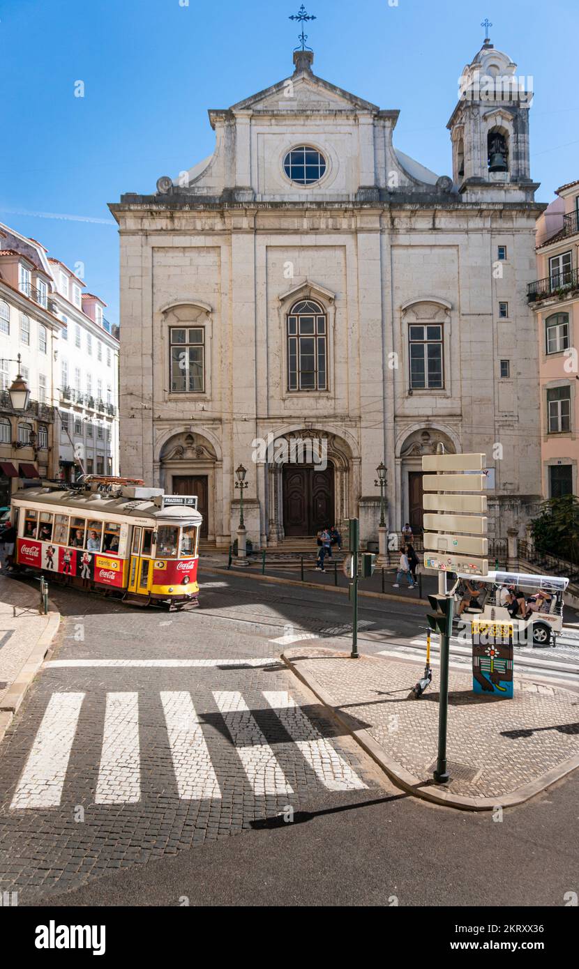 Vista sulla strada di un tram che passa di fronte a una chiesa nella città di Lisbona, Portogallo Foto Stock
