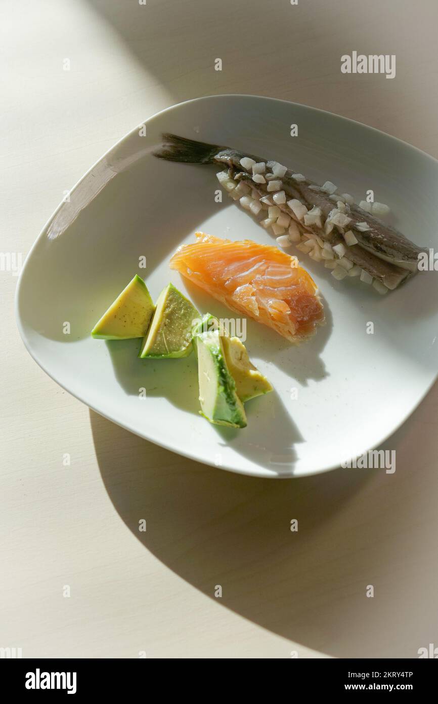 Piatto da pranzo con pasto sano con grassi insaturi con pesce grasso, aringhe, salmone e avocado Foto Stock