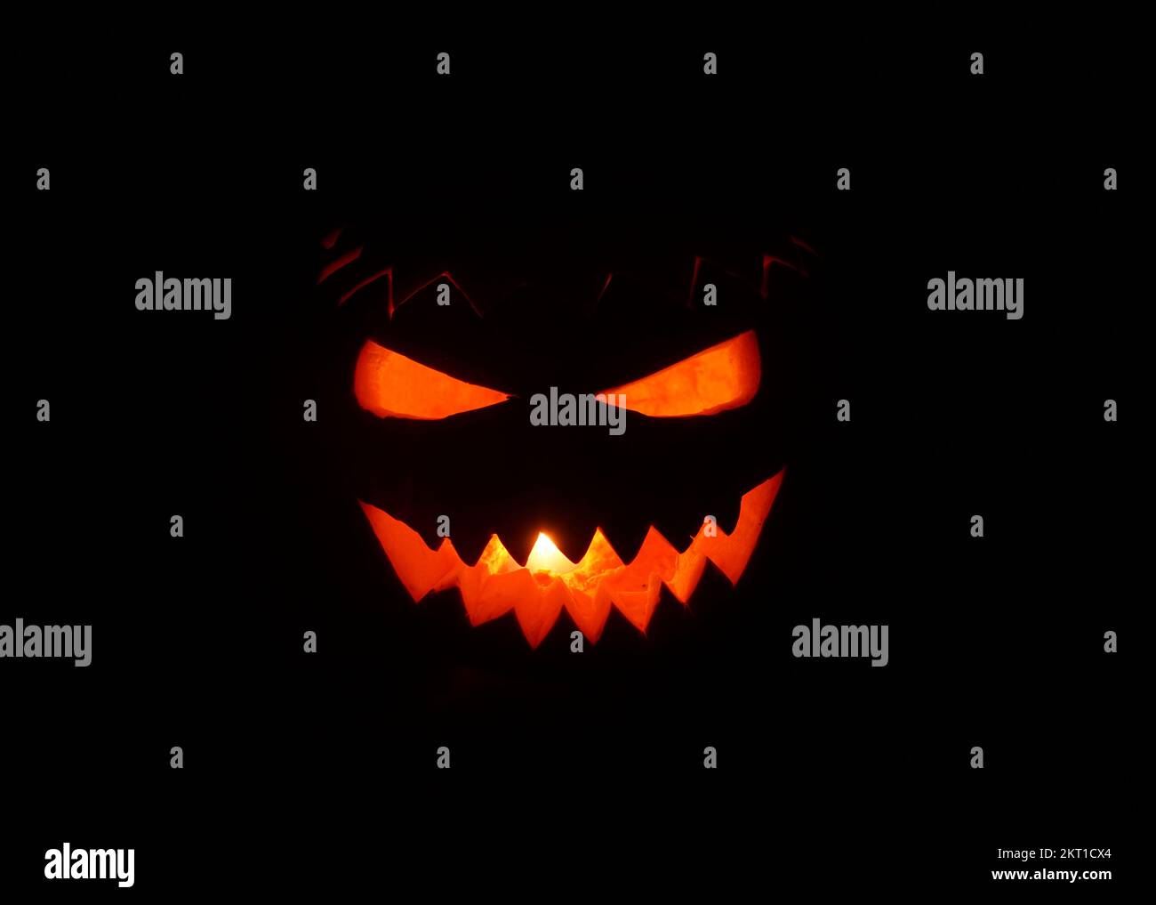 Zucca di Halloween creativa scolpita che risplenderà al buio su un davanzale Foto Stock