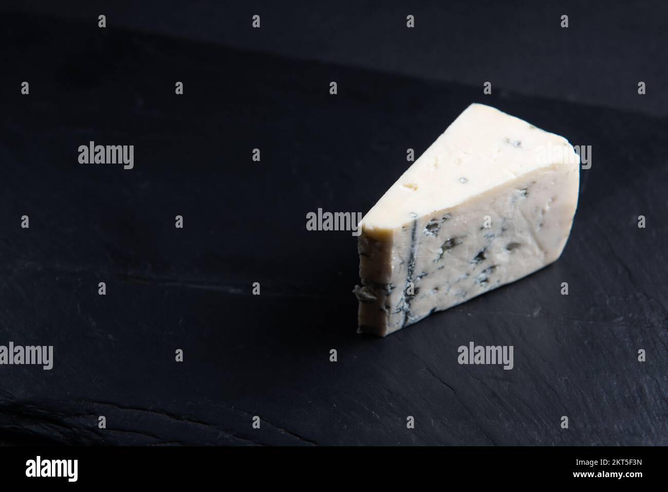 Formaggio blu, blu dor o roquefort stampo fetta di formaggio sul tagliere con foglie di basilico, cibo lifestyle. Foto Stock
