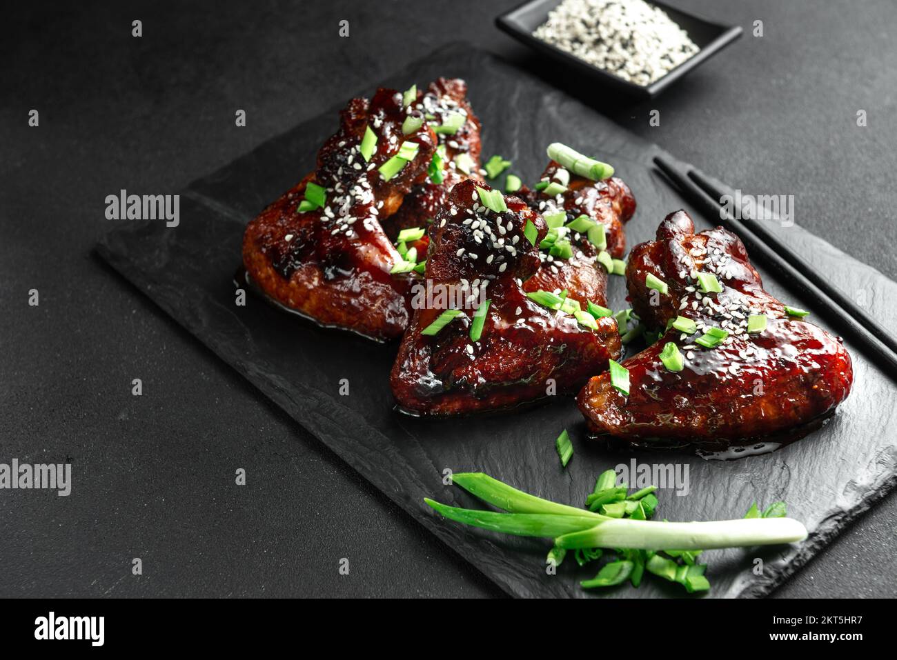 Ali di pollo. Ricetta asiatica tradizionale. Sfondo scuro. Vista dall'alto. Ali di pollo in salsa teriyaki. Ali di pollo asiatiche su sfondo scuro Foto Stock