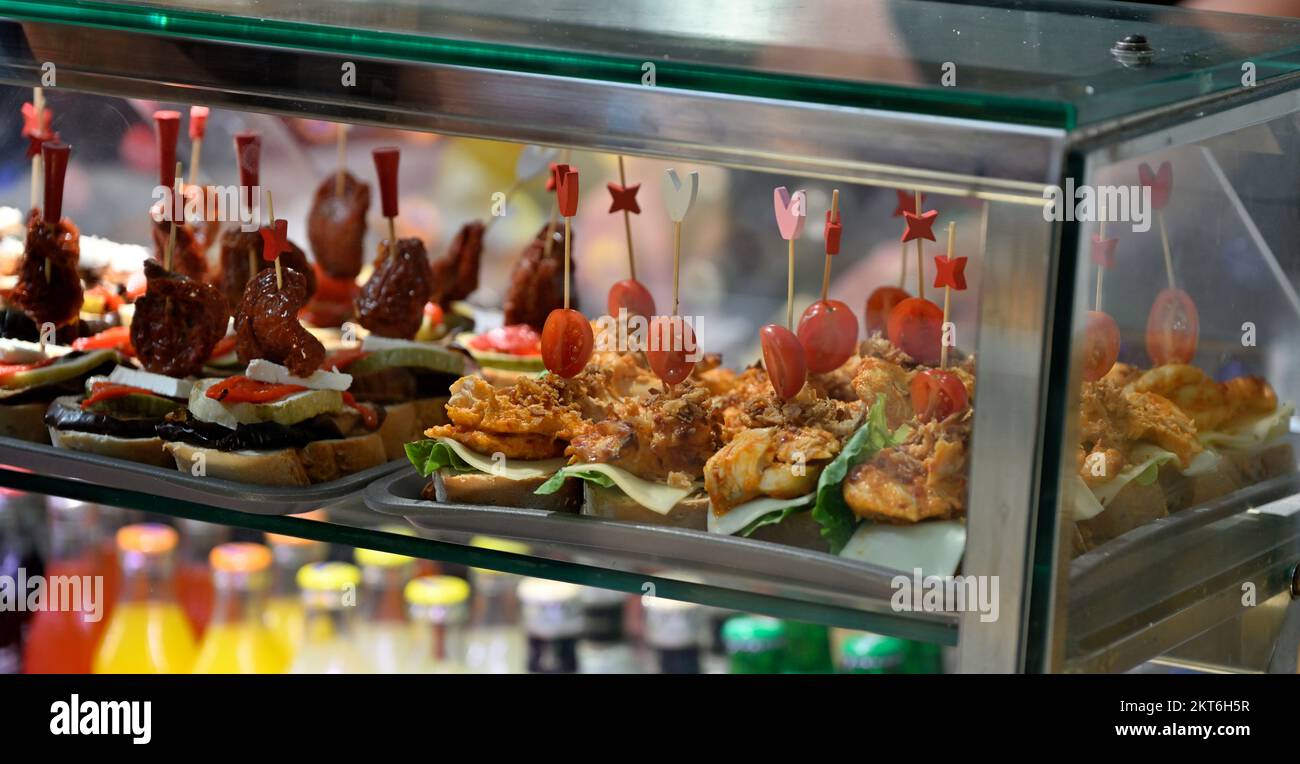 Mostra di piccoli spuntini, 'pinchos', in un tapas cafe all'interno del Mercado del Puerto, il mercato sul porto Foto Stock