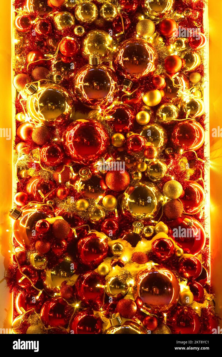 Sfondo festivo di brillanti palle di Natale rosse e dorate. Decorazione natalizia di vetrina, installazione in vendita stagione Foto Stock