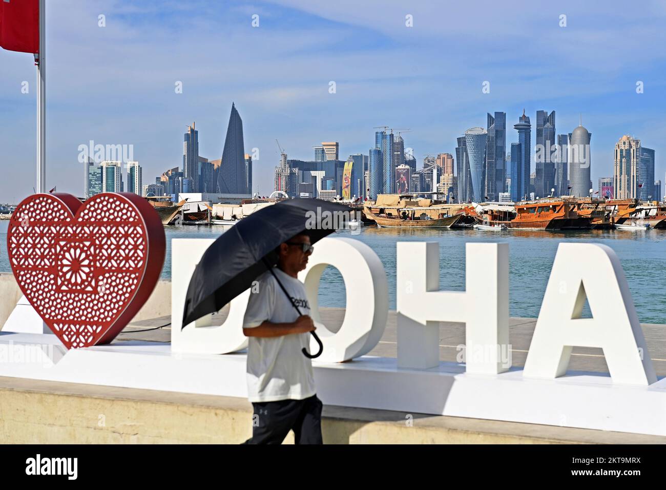 Impressioni da Doha/Qatar il 29th novembre 2022. FIFA Fanfest, Corniche West Bay.The Corniche. Amo Doha, Skiyline, Silhouette, Skyscraper. Uomo con ombrello Coppa del mondo di calcio 2022 in Qatar dal 20,11. - Dalle 18.12.2022 alle Foto Stock