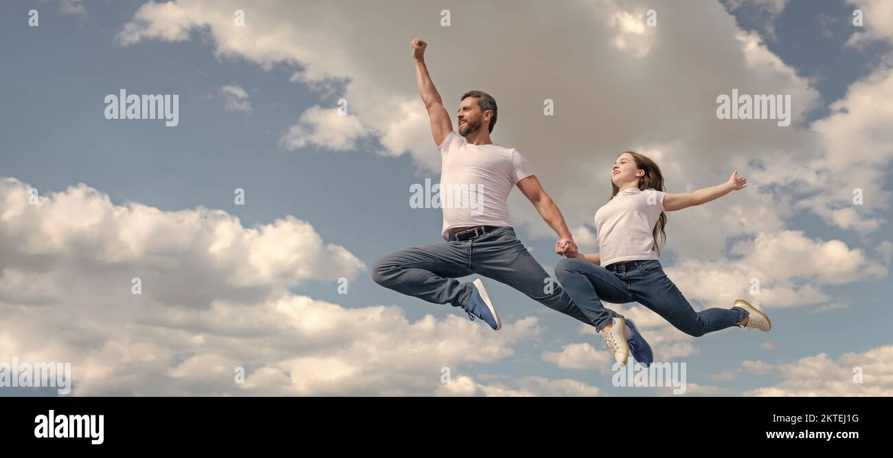 Padre e figlia saltano sul cielo, bandiera con spazio copia. Papà felice e figlia saltano nel cielo. Giorno della famiglia Foto Stock