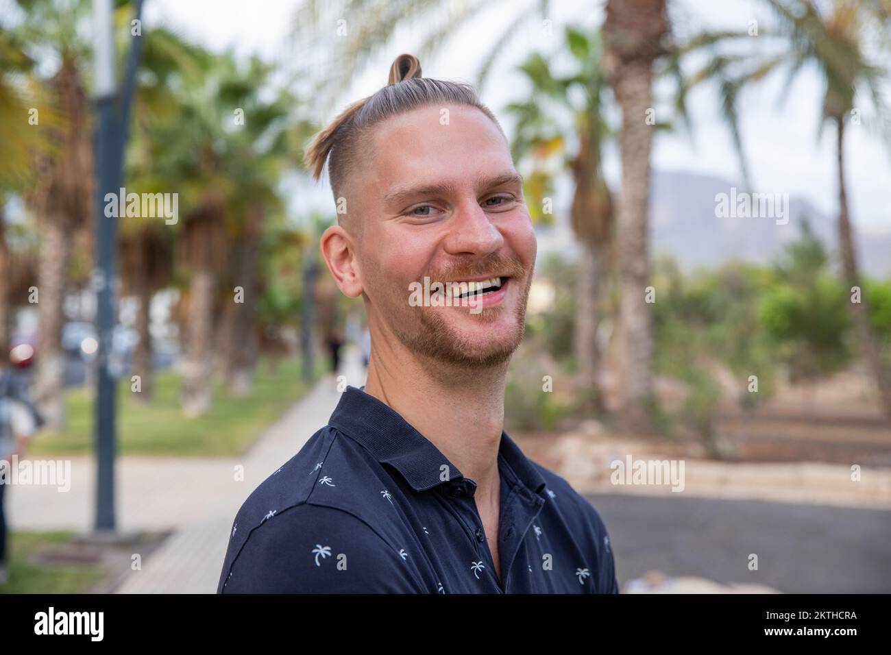 Ritratto di un attraente ragazzo caucasico sorridente all'aperto, persona nel suo 30s Foto Stock