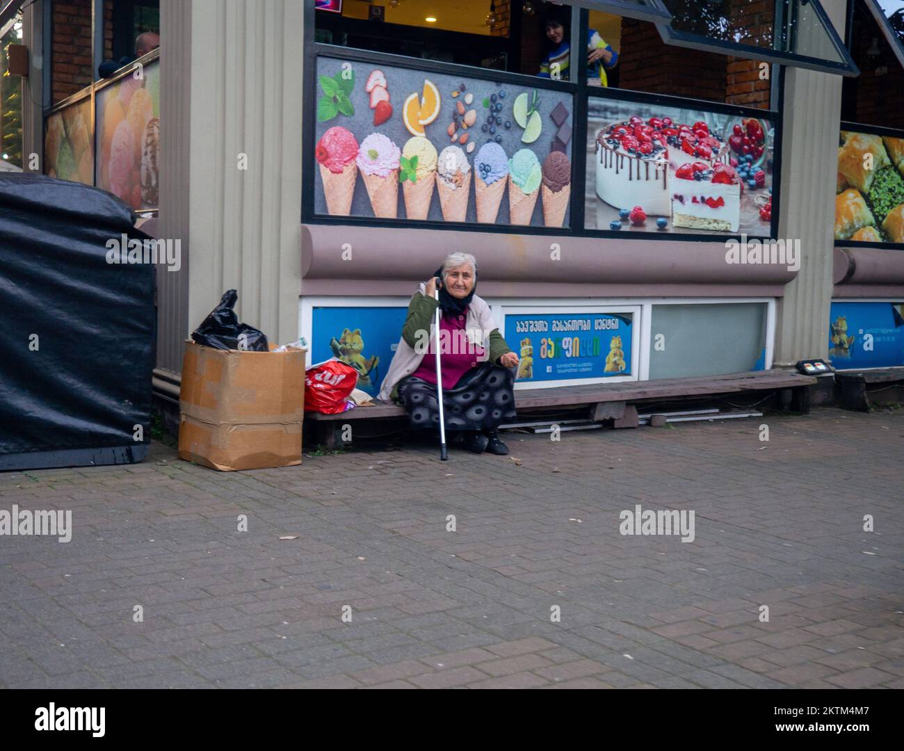 Batumi, Georgia. 11.21.2022 Beggars in città. Nonna con mano tesa. Un uomo si siede contro un muro nella strada. chiede denaro Foto Stock
