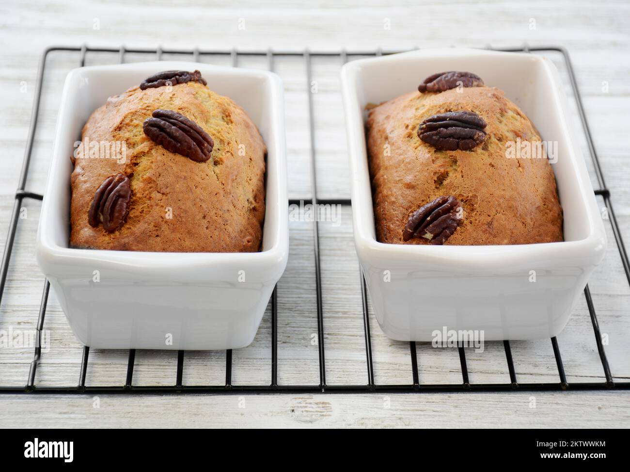 Mini focacce di banana appena sfornate con noci pecan raffreddate su rack in formato orizzontale. Foto Stock