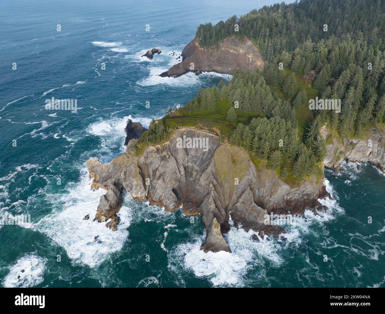 Il freddo Oceano Pacifico si bagna contro la costa frastagliata dell'Oregon settentrionale. Questo nord-ovest del Pacifico è noto per il suo spettacolare paesaggio all'aperto. Foto Stock
