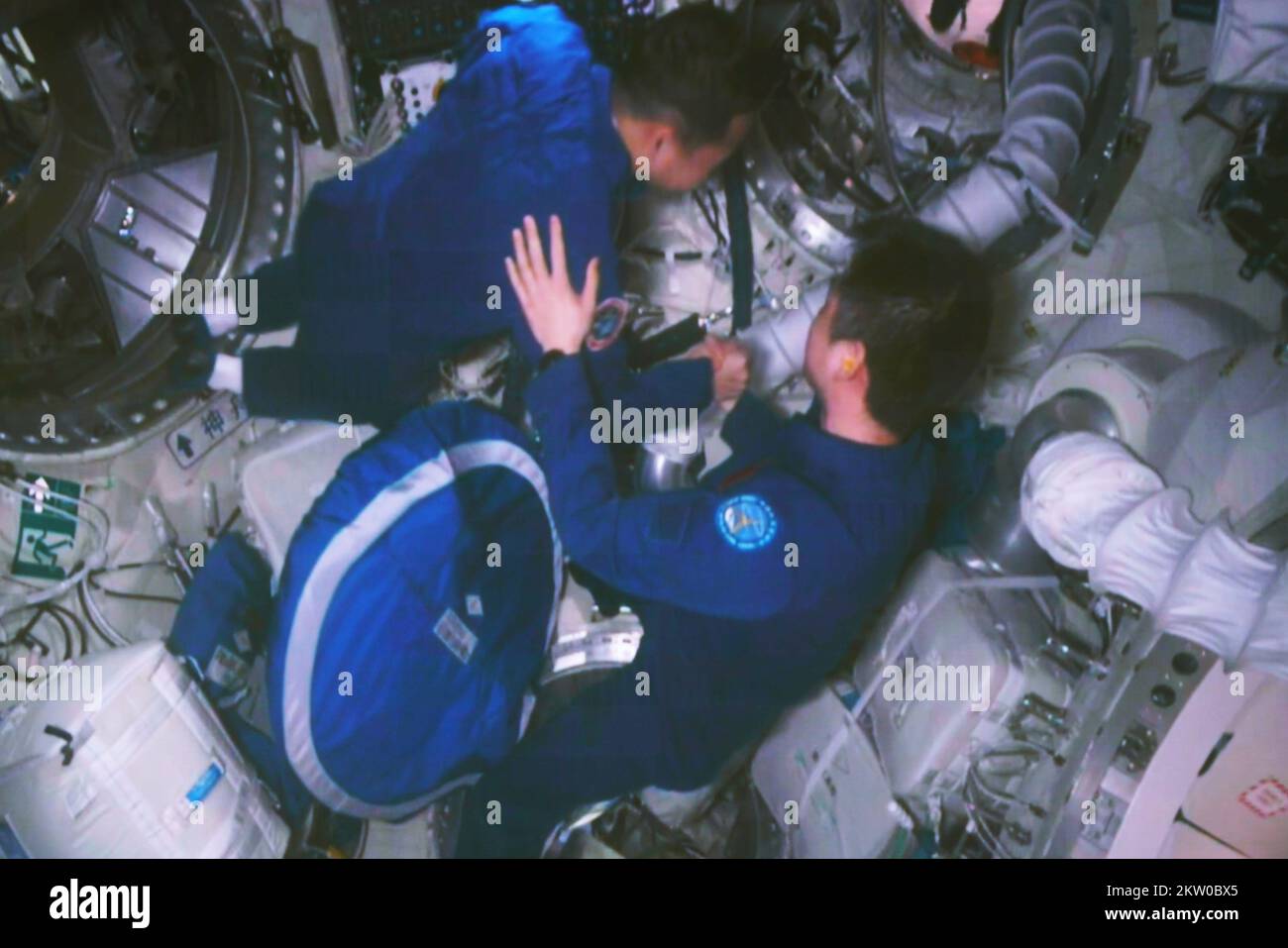 (221130) -- JIUQUAN, 30 novembre 2022 (Xinhua) -- questa immagine catturata al Jiuquan satellite Launch Center nel nord-ovest della Cina mostra Chen Dong, il comandante dell'equipaggio Shenzhen-14, che saluta l'equipaggio Shenzhen-15 alla cabina di blocco aereo del modulo Tianhe della stazione spaziale il 30 novembre 2022. I tre astronauti a bordo della nave spaziale Shenzhen-15 della Cina entrarono nella stazione spaziale del paese e si incontrarono con un altro trio di astronauti mercoledì, un incontro storico che aggiunse per la prima volta la forza lavoro nel laboratorio spaziale in orbita a sei. Chen Dong, comandante dell'equipaggio Shenzhen-14, aprì il portello Foto Stock