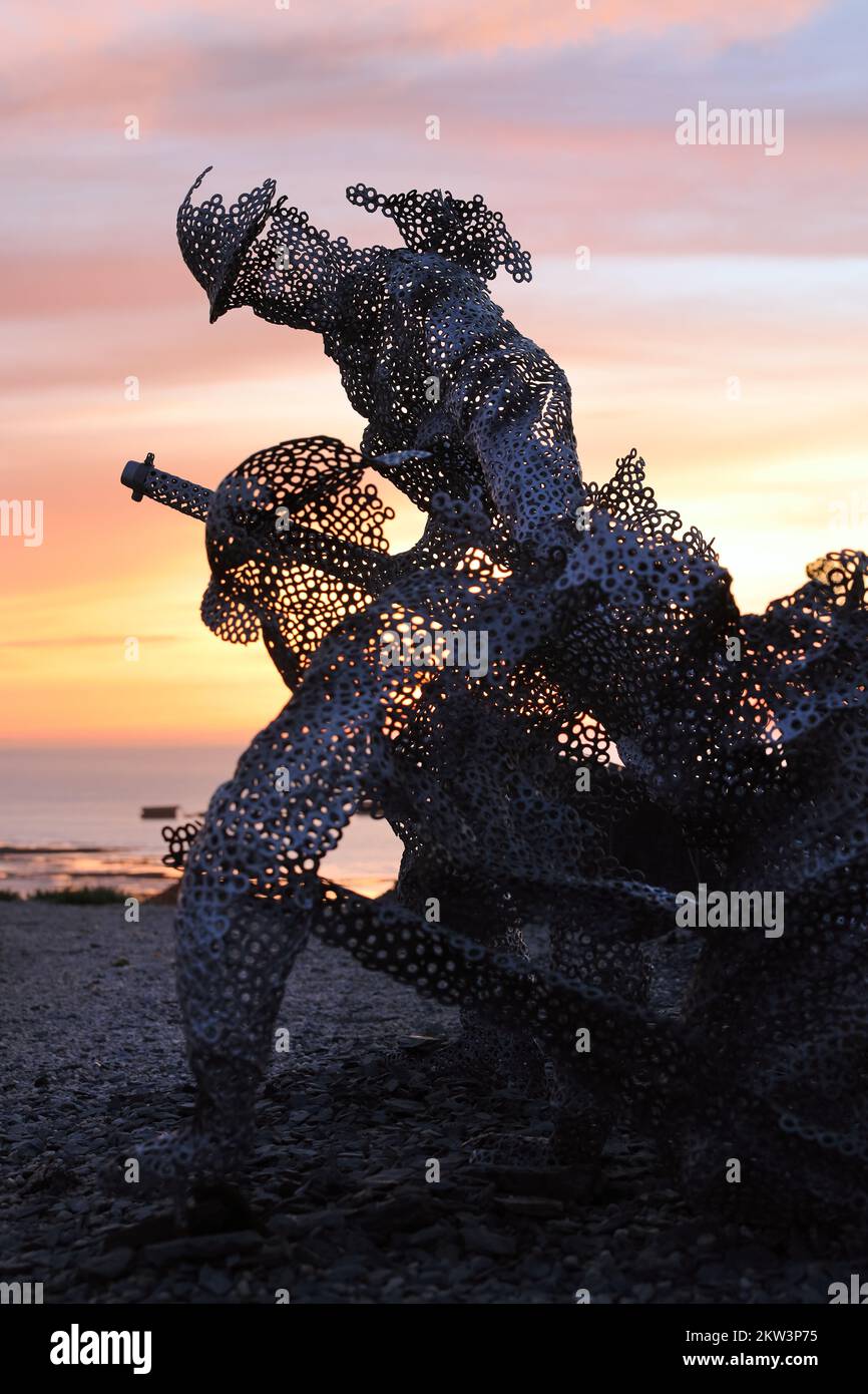 Figura scultorea a grandezza naturale nel giardino D-Day 75 a Arromanches-les-Bains, Francia al tramonto. L'installazione è stata creata per la prima volta da John Everiss for Foto Stock