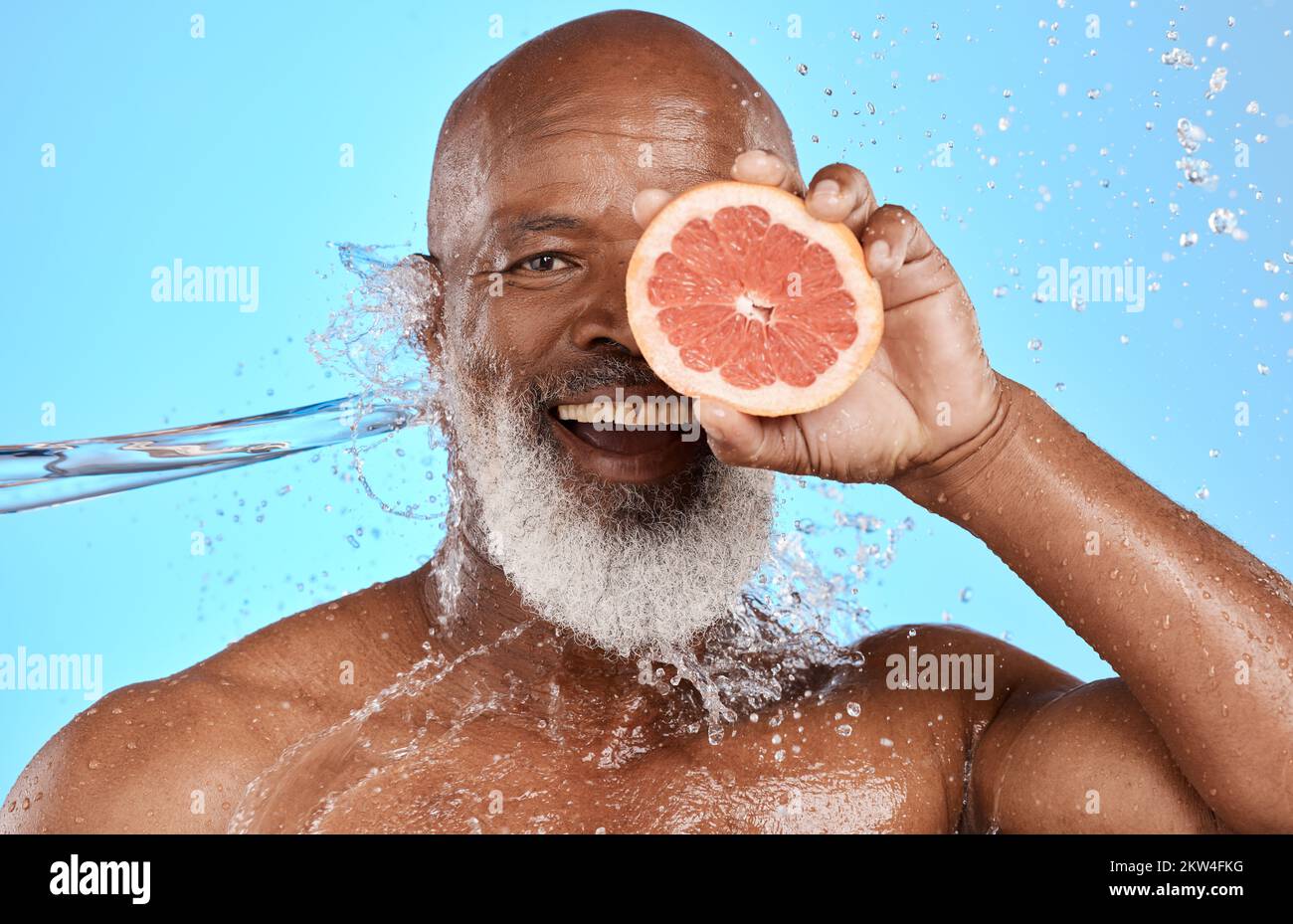 Pompelmo, ritratto e uomo nero anziano in studio con spruzzi d'acqua per prodotti da bagno, cura della pelle e promozione salute vitamina C. Sorridere, frutta Foto Stock