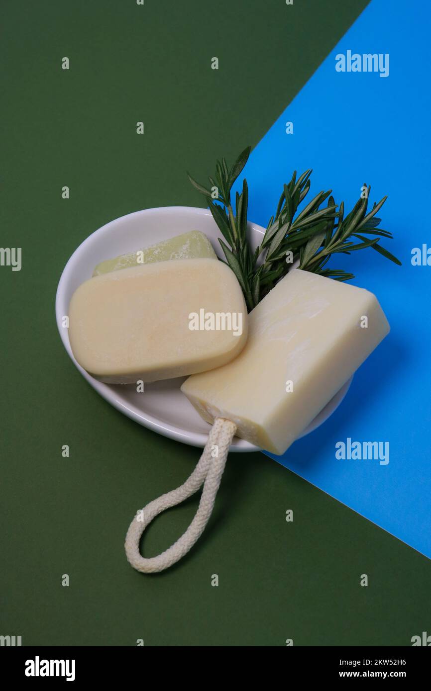 primo piano delle saponette fatte a mano su un vassoio per sapone bianco, fondo verde Foto Stock