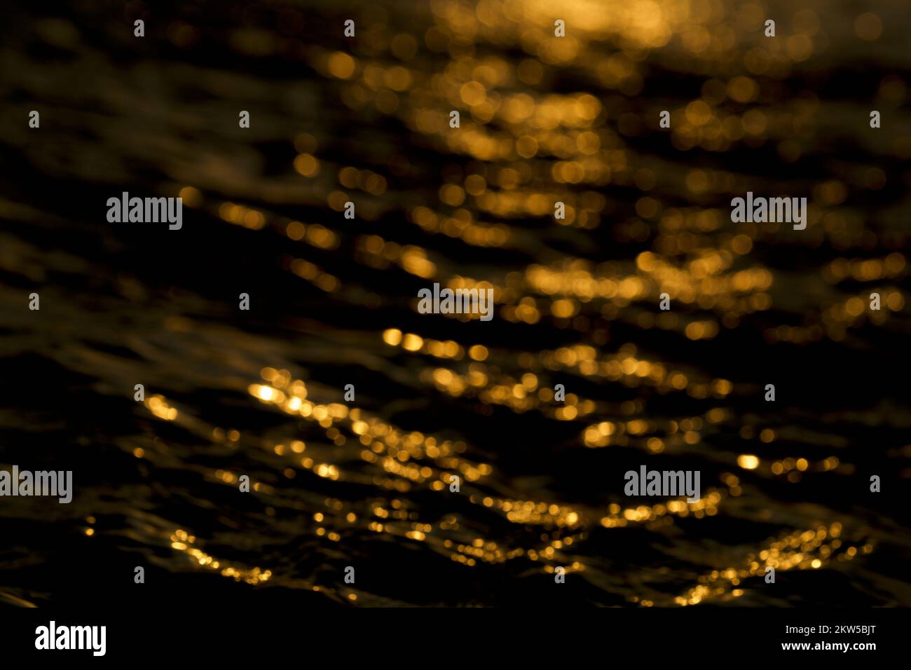 luce bokeh isolata su sfondo nero. Effetto luce bokeh sull'acqua. Foto Stock