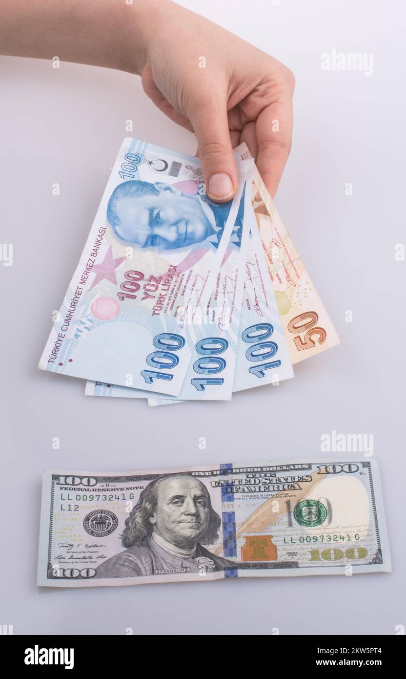 Mani Turksh Lira banconote dal lato del dollaro americano banconote su sfondo bianco Foto Stock