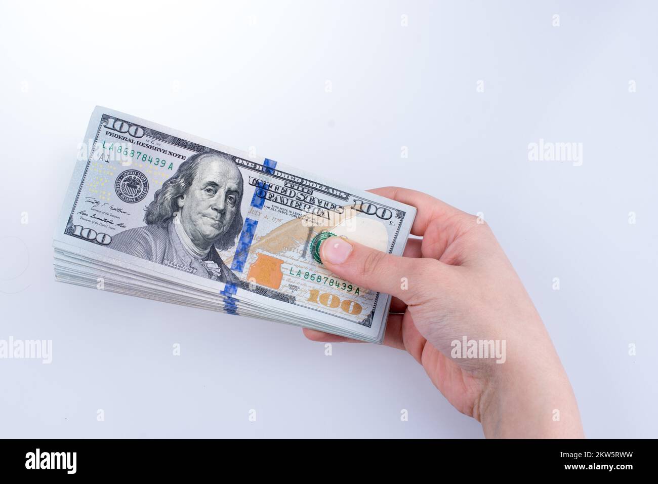 Mano umana tenendo dollaro americano Bill come denaro isolato su bianco Foto Stock